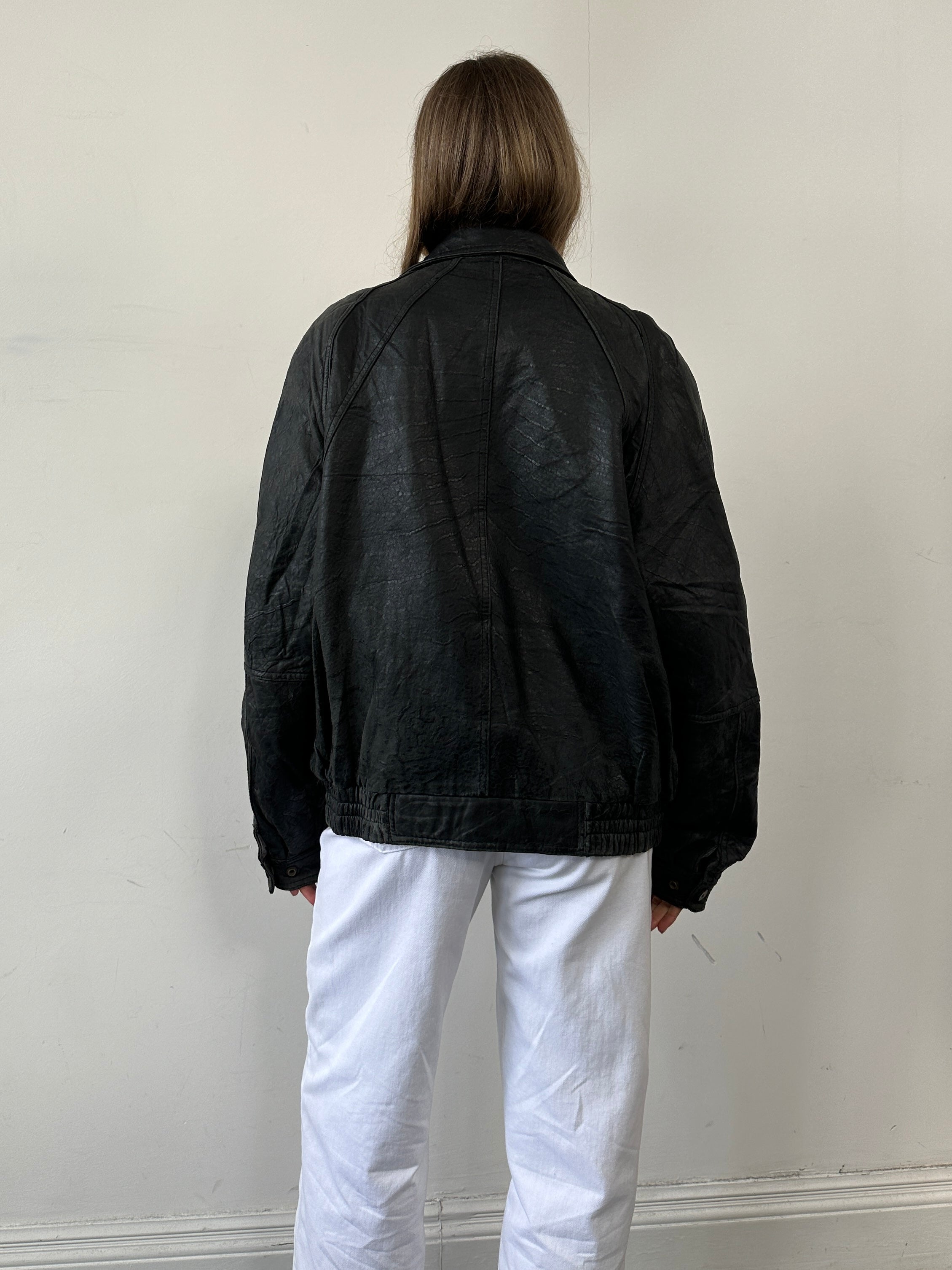 Vintage distressed leather bomber jacket in size large, featuring a rugged, worn-in look and classic style.