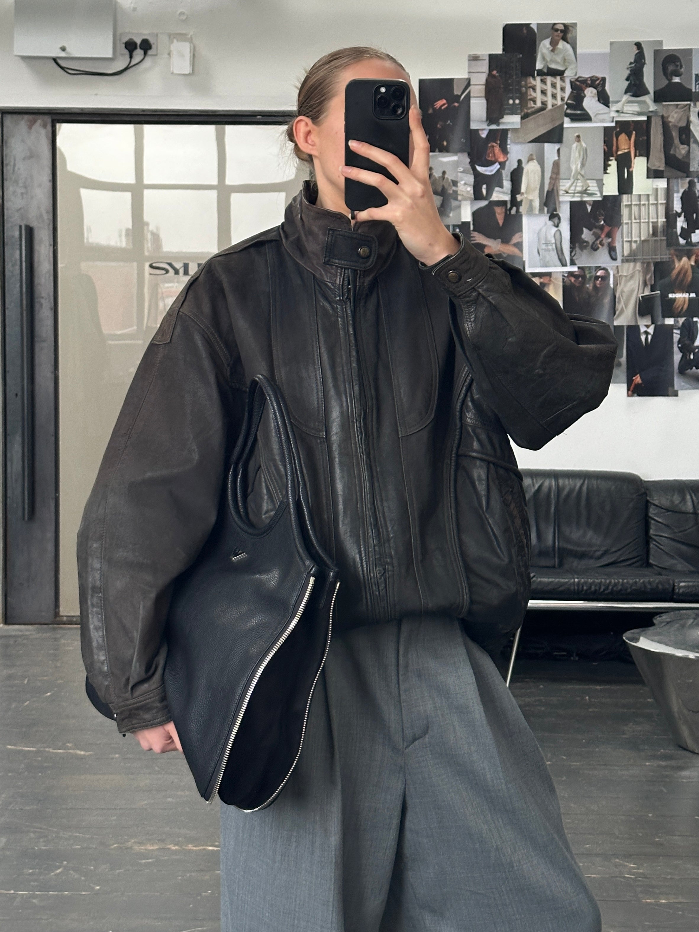 Vintage 1990s aged leather bomber jacket in XL, featuring distressed brown leather and classic ribbed cuffs and collar.