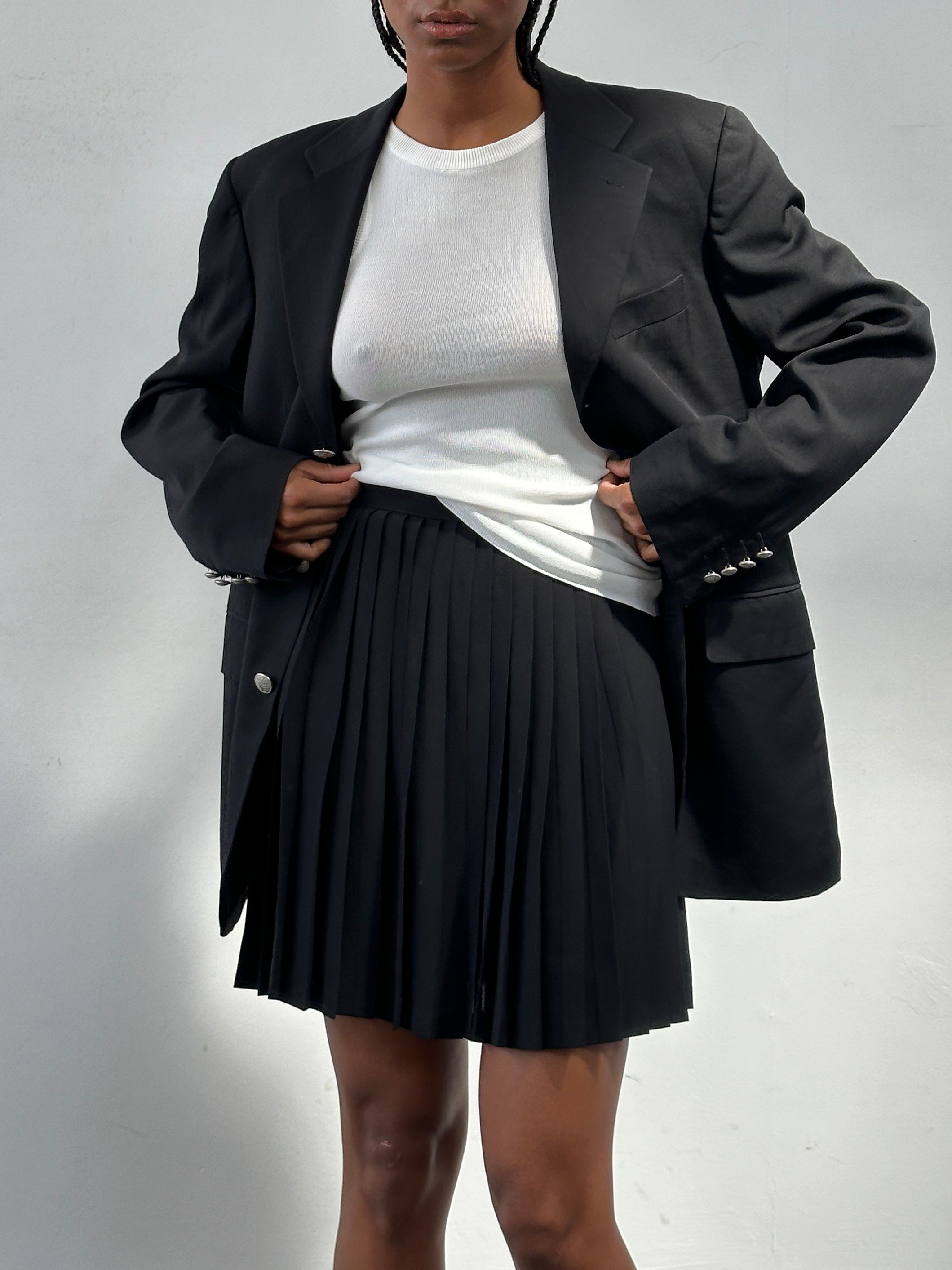 Vintage Italian 1990s pleated A-line mini skirt in W26, showcasing classic retro style and lightweight fabric.