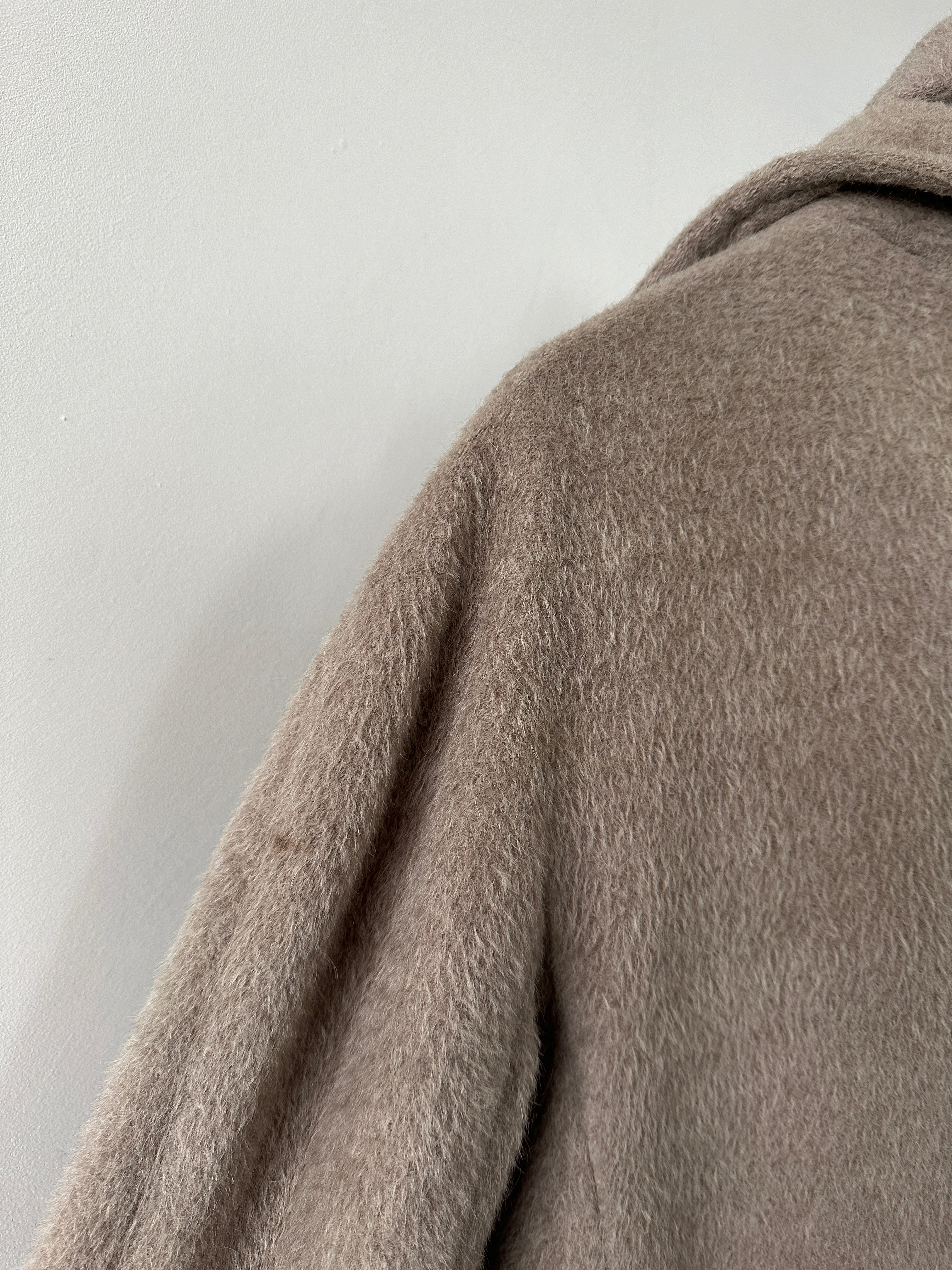 Max Mara alpaca wool belted wrap coat in beige, featuring a tailored collar and long sleeves, displayed on a hanger.