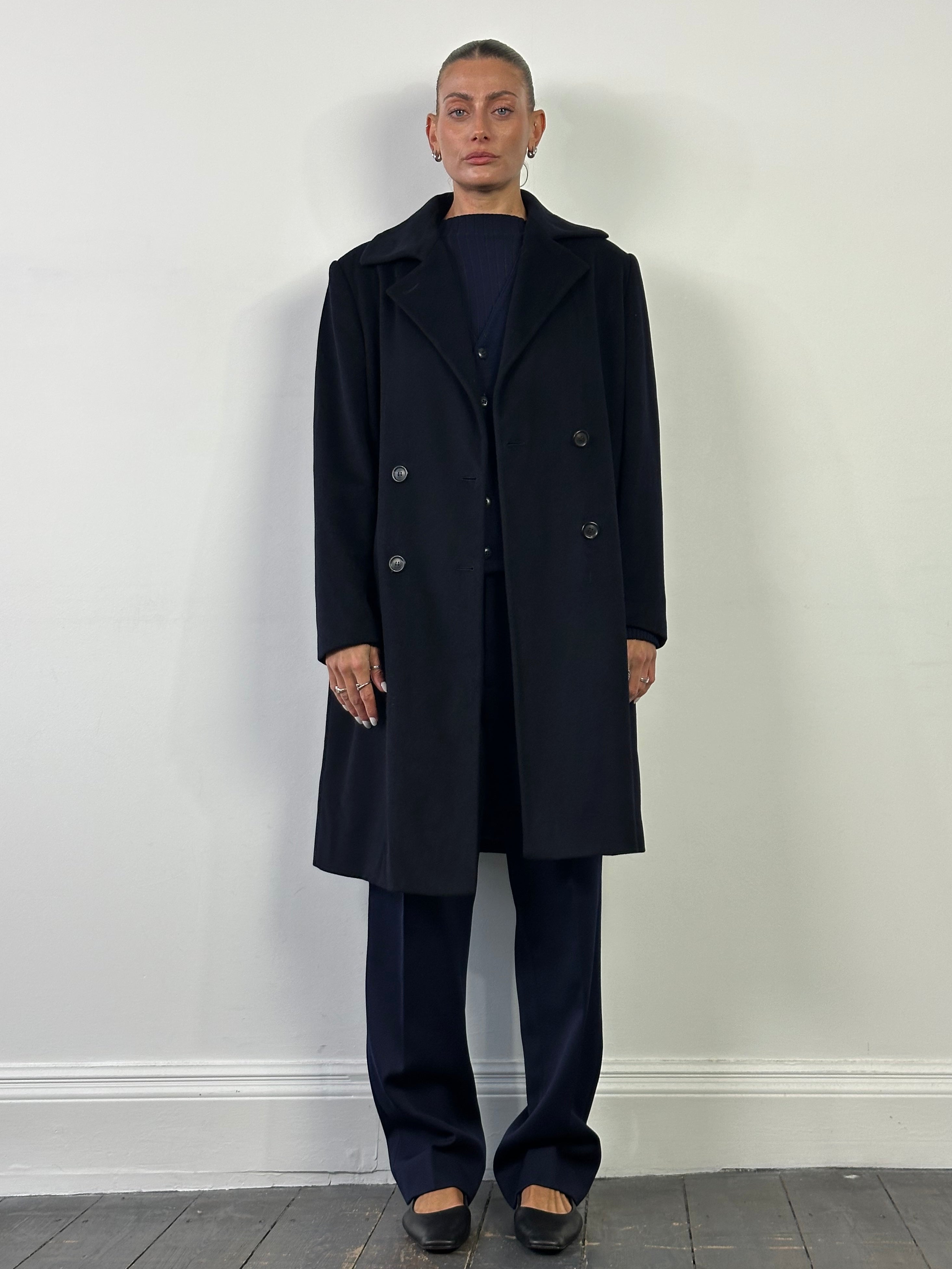 Loro Piana pure wool double-breasted coat in size L/XL, shown on a hanger, featuring classic tailored design and neutral color.