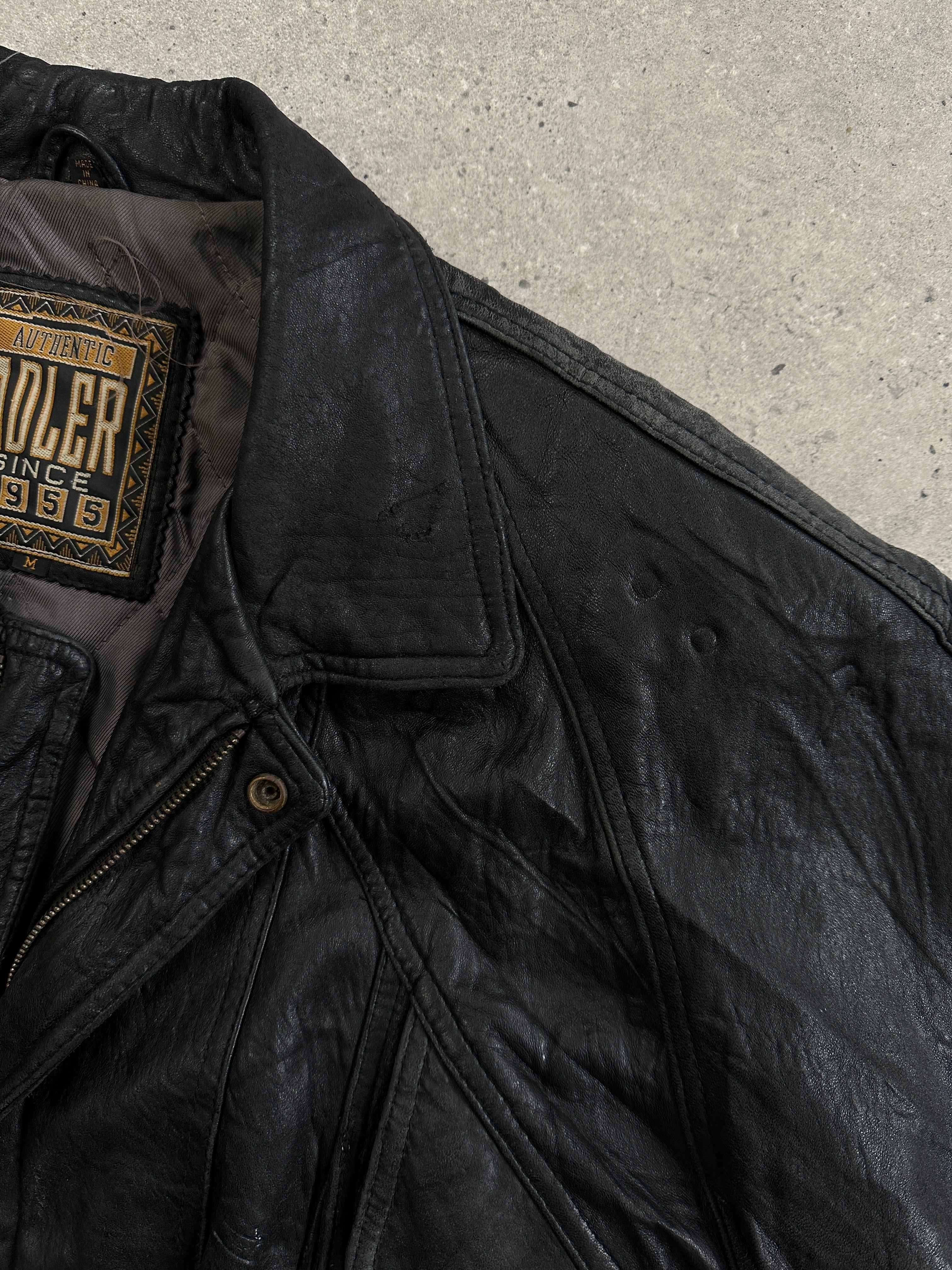 Vintage distressed leather bomber jacket in size large, featuring a rugged, worn-in look and classic style.