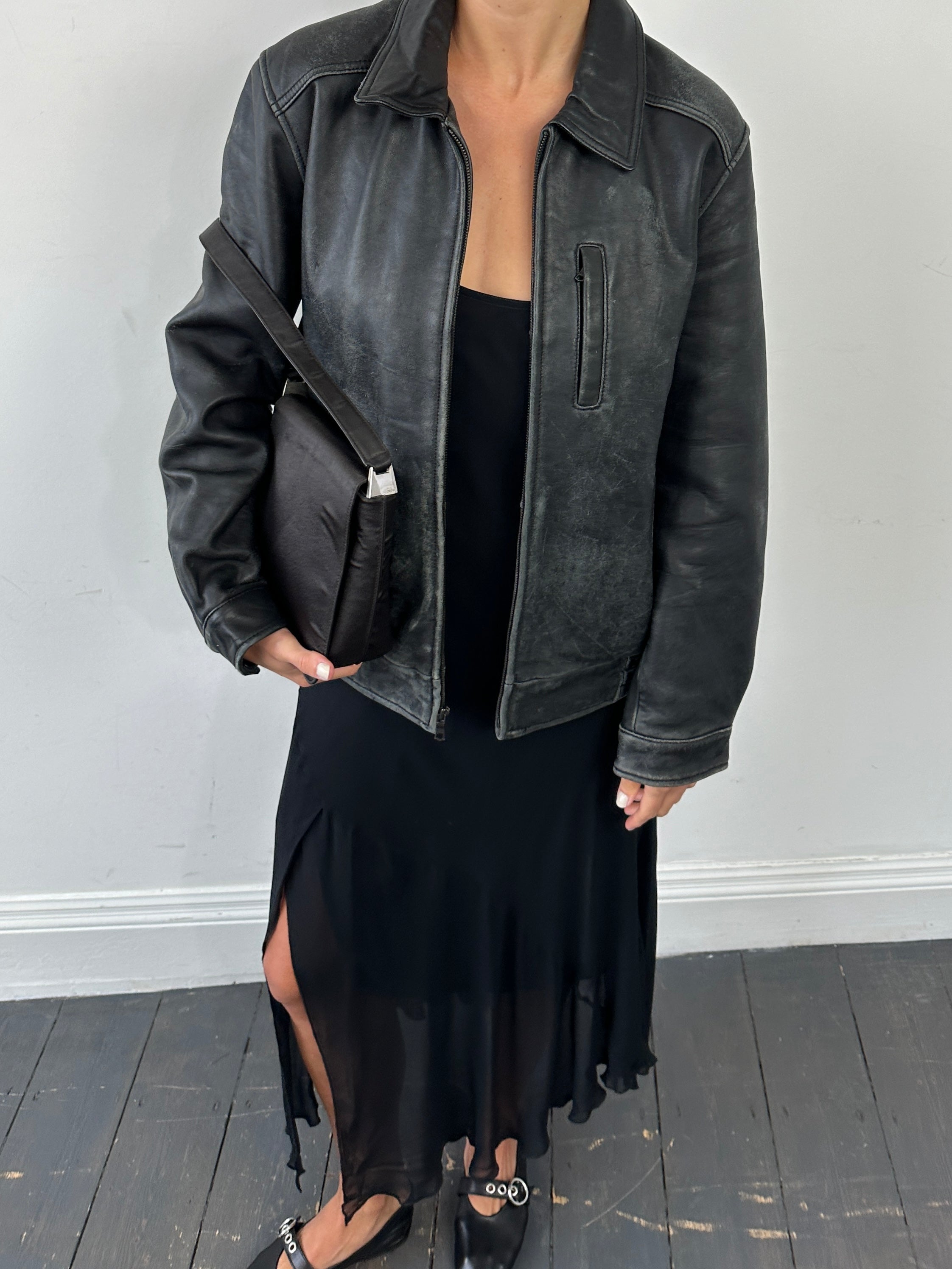 Tommy Hilfiger distressed leather bomber jacket in size M with a classic collar and zip front, displayed on a hanger.