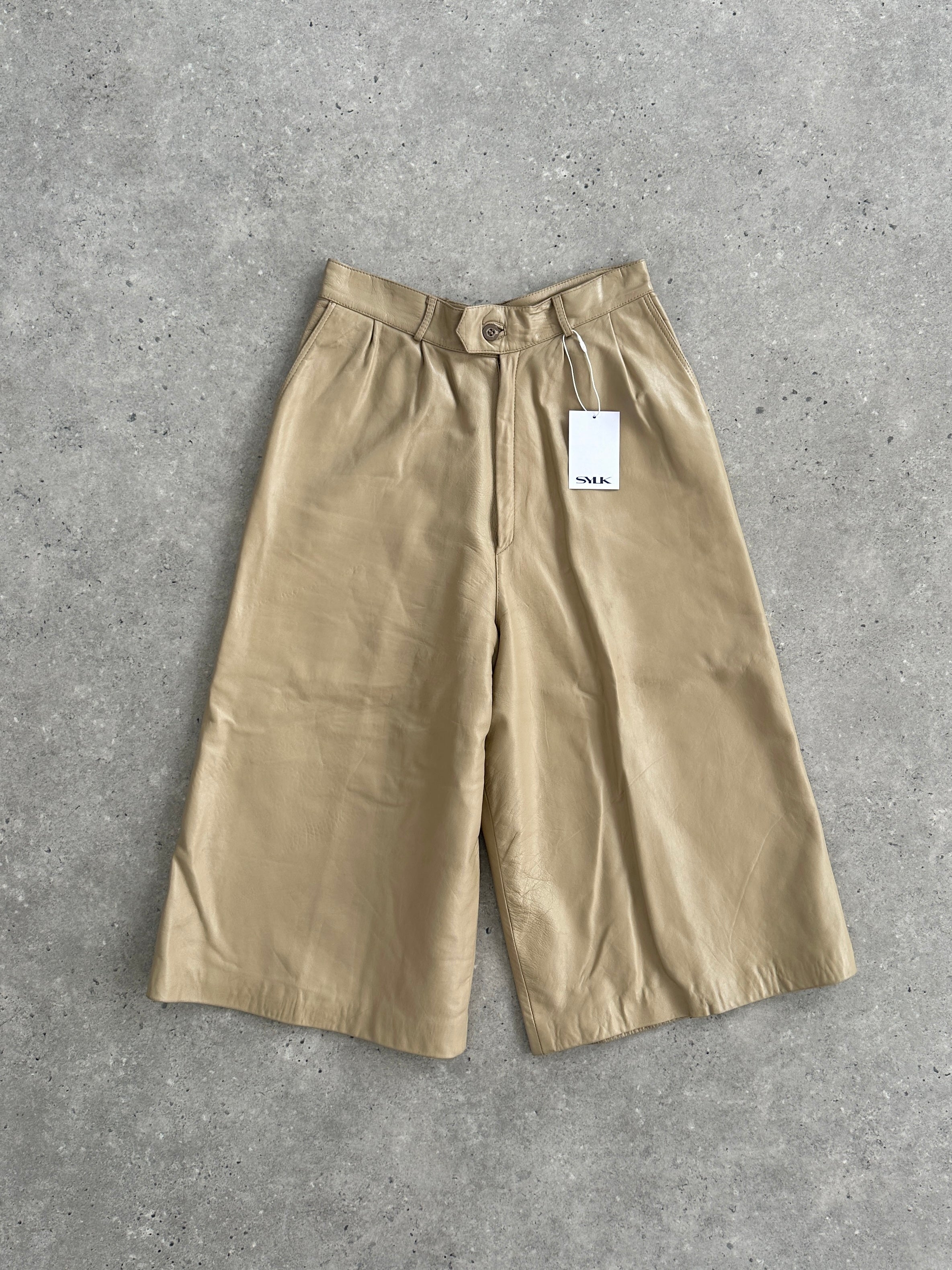 Vintage leather wide-leg high-waisted long shorts, stylish and retro, shown in natural light with a relaxed fit and classic design.