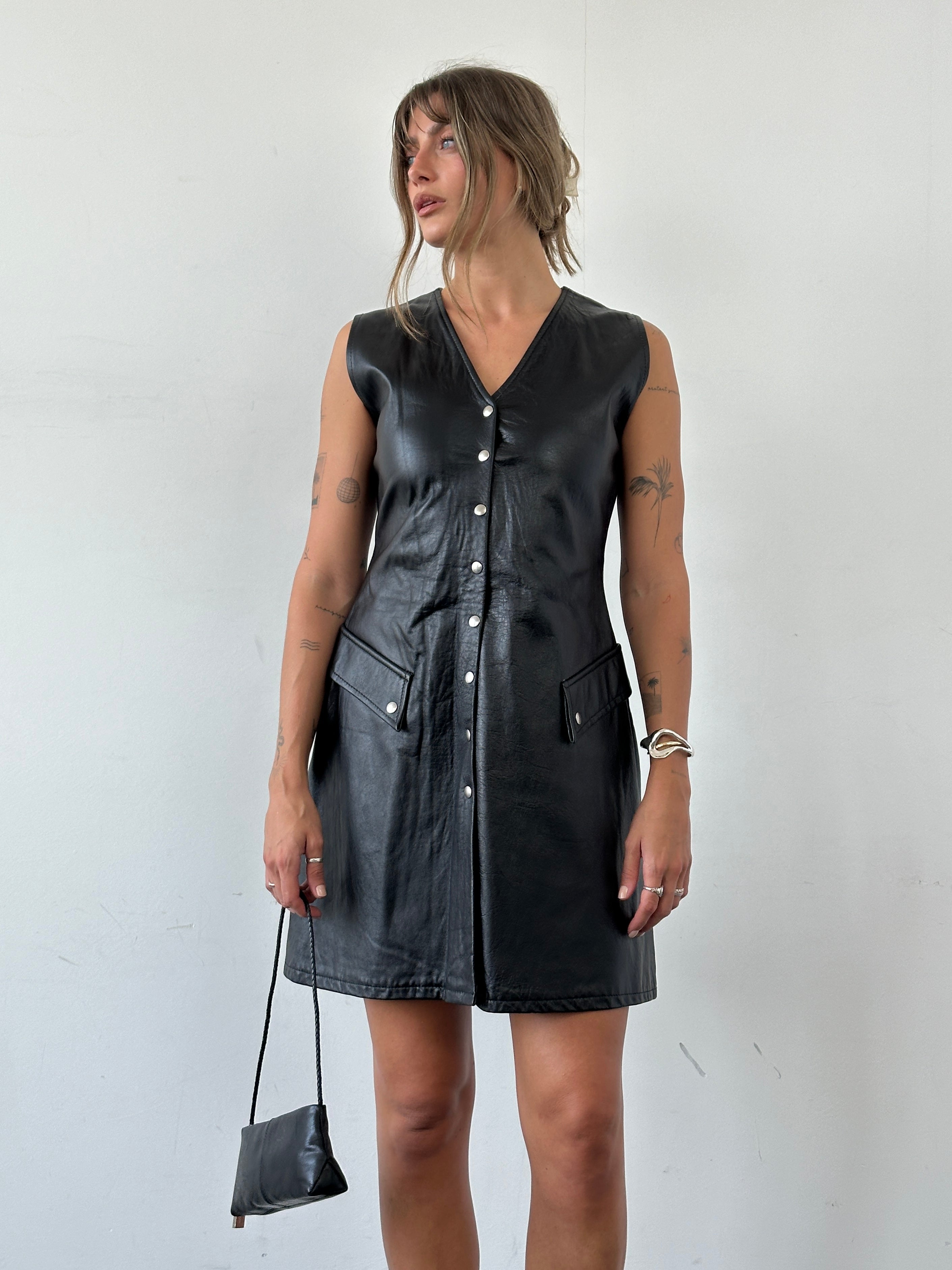 Vintage fitted leather dress with button-up front, short sleeves, and classic silhouette in size S.