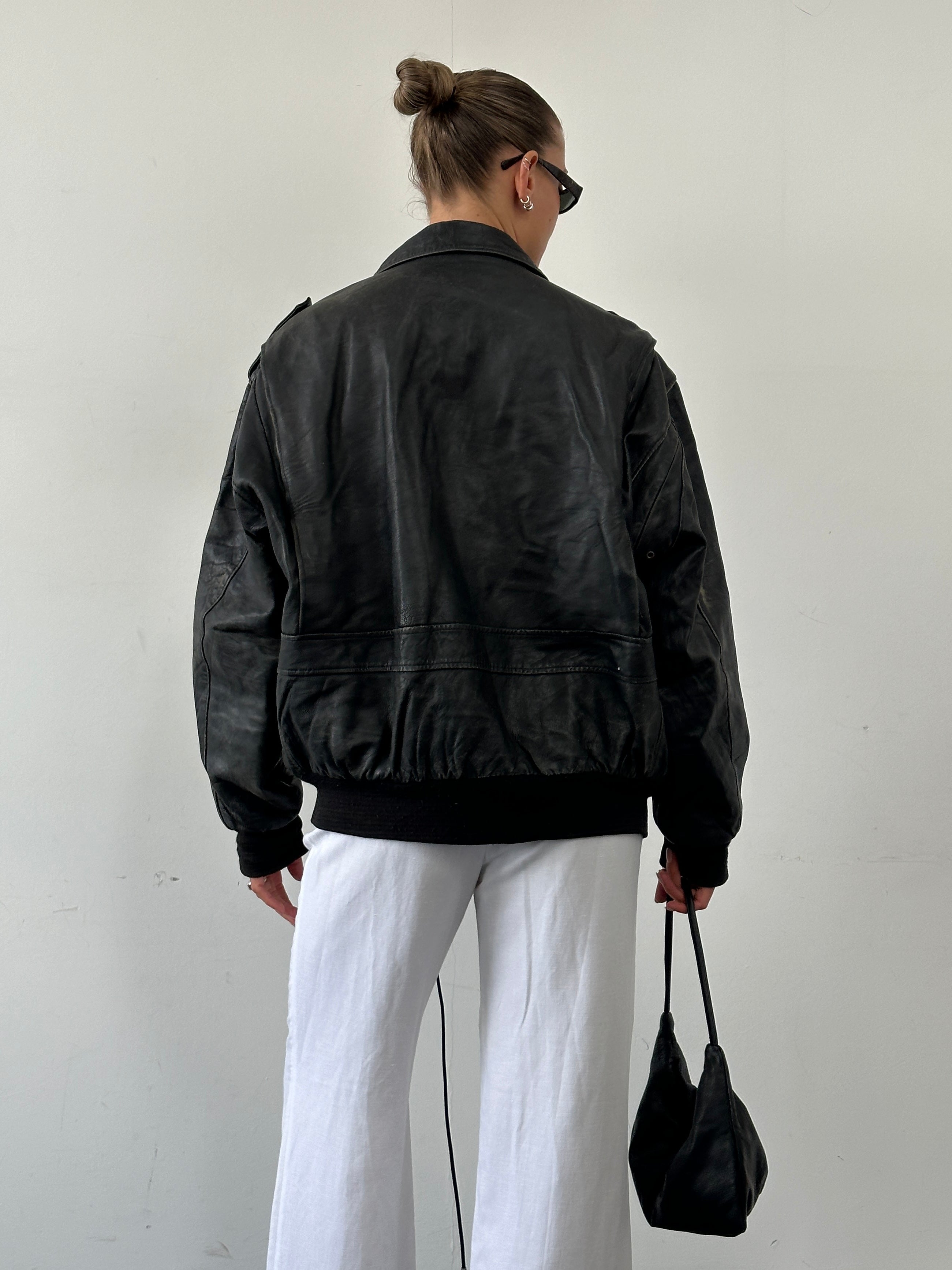 Vintage distressed leather bomber jacket in XL with rugged style, featuring classic design and aged leather texture.