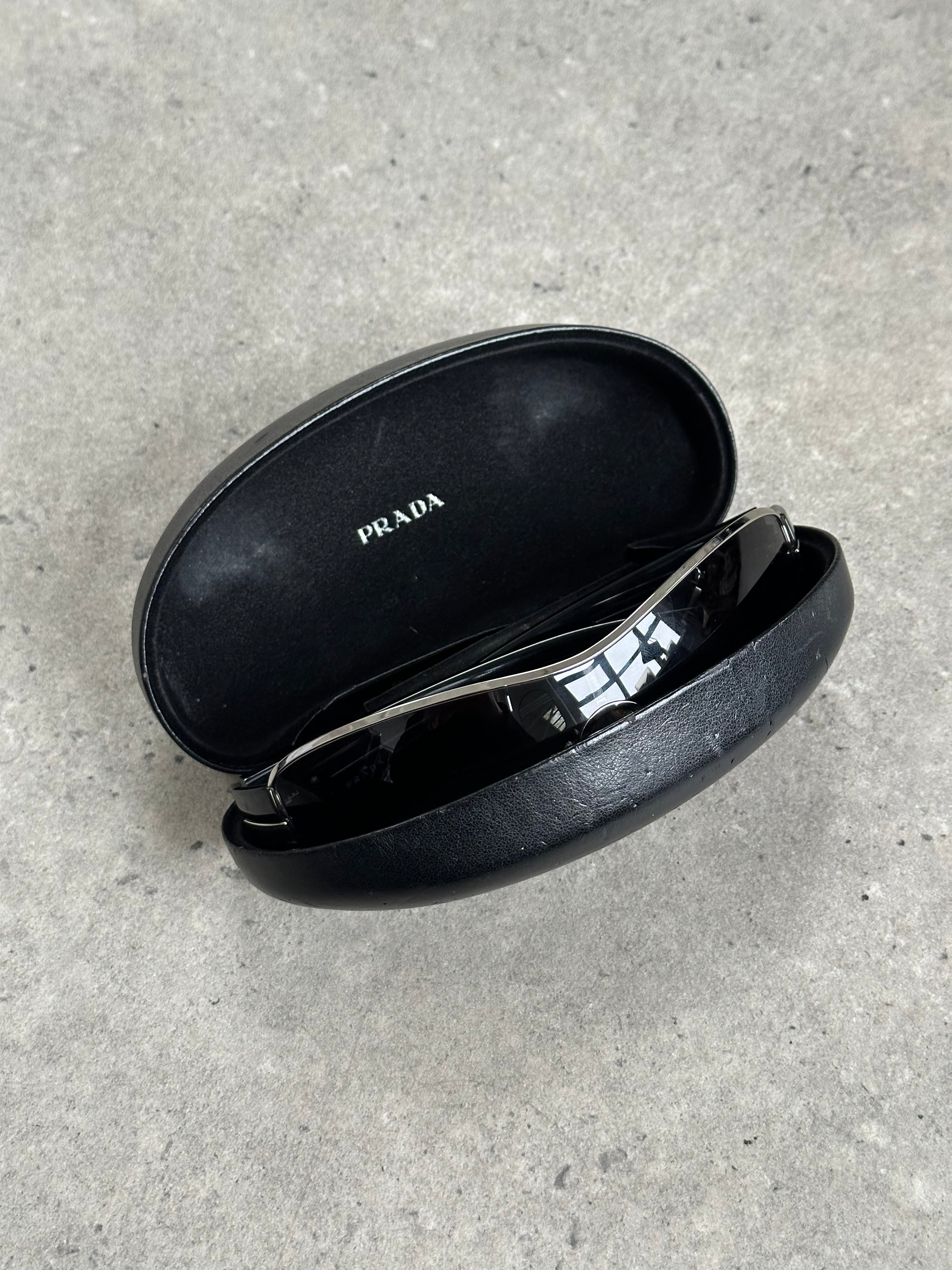 Prada 2000s aviator shield sunglasses with large dark lenses and metal frame, stylish and iconic eyewear accessory.