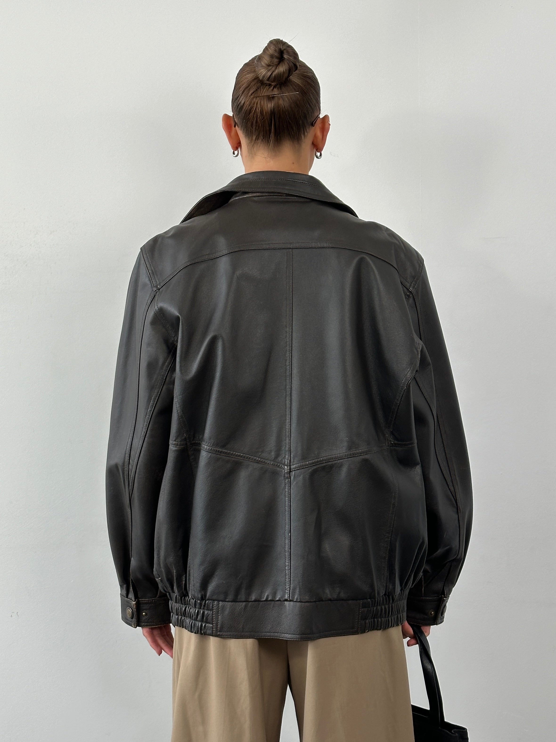 Vintage leather blouson bomber jacket in XL size, featuring classic design and durable material, shown on a hanger.