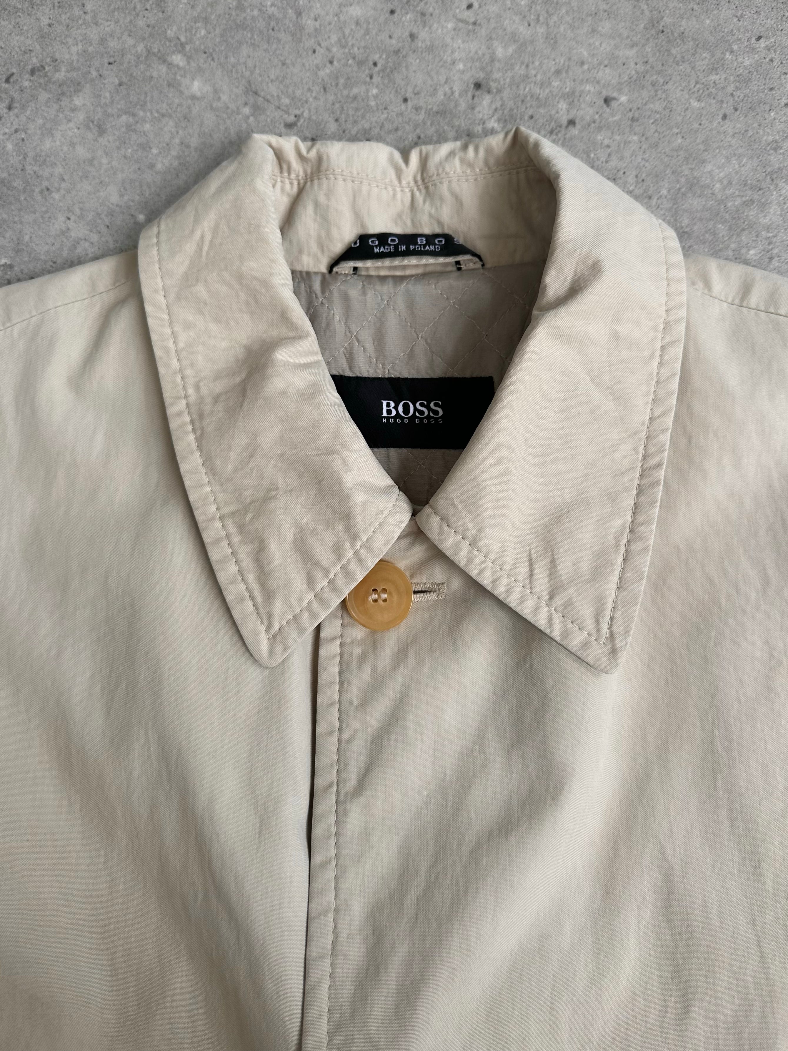 Hugo Boss 2000s cotton trench coat with concealed placket, beige color, classic long sleeve design, and tailored fit.