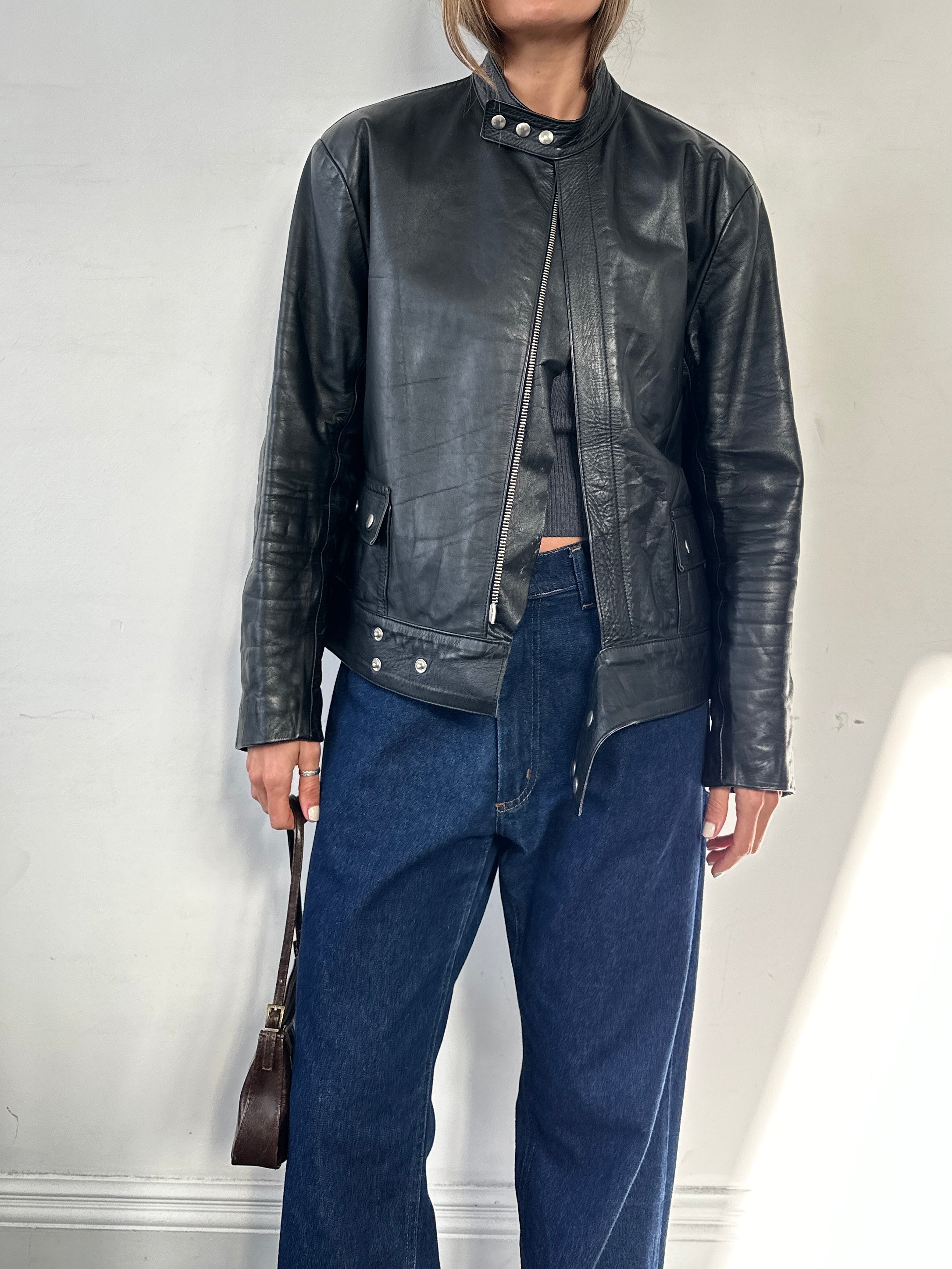 Vintage leather moto jacket in size large, featuring classic design and sturdy craftsmanship, perfect for a stylish, edgy look.