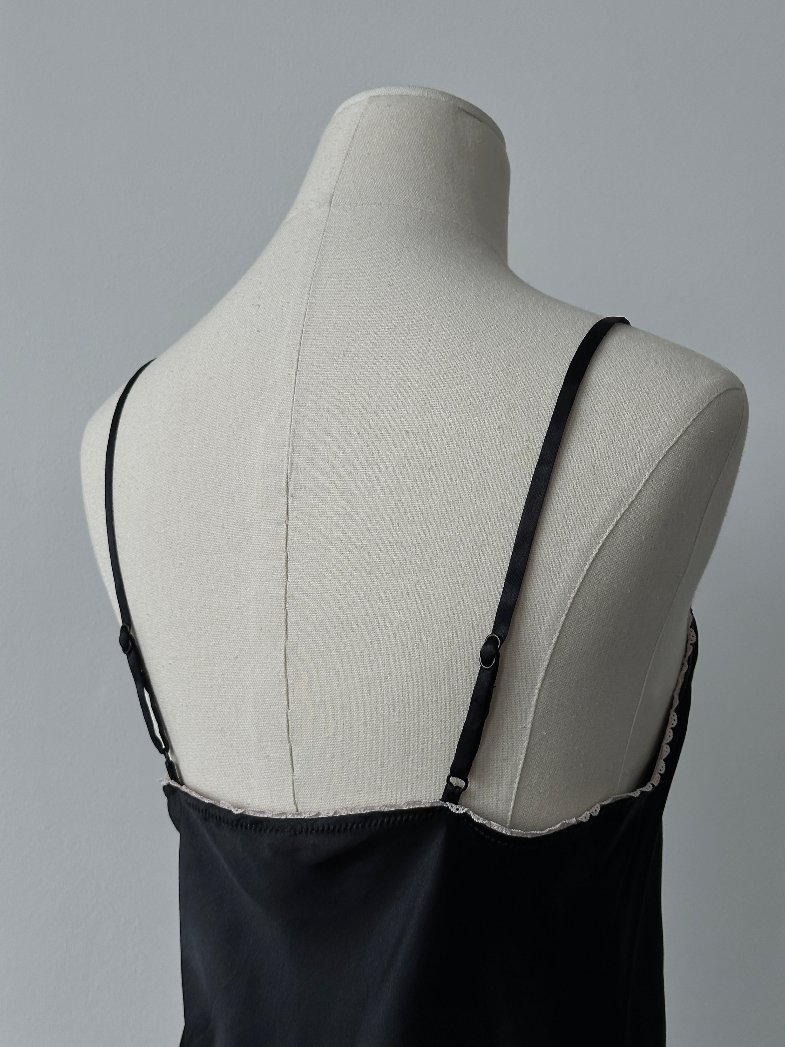 Vintage 1990s satin lace mini slip dress in black, featuring delicate lace details and a fitted silhouette.