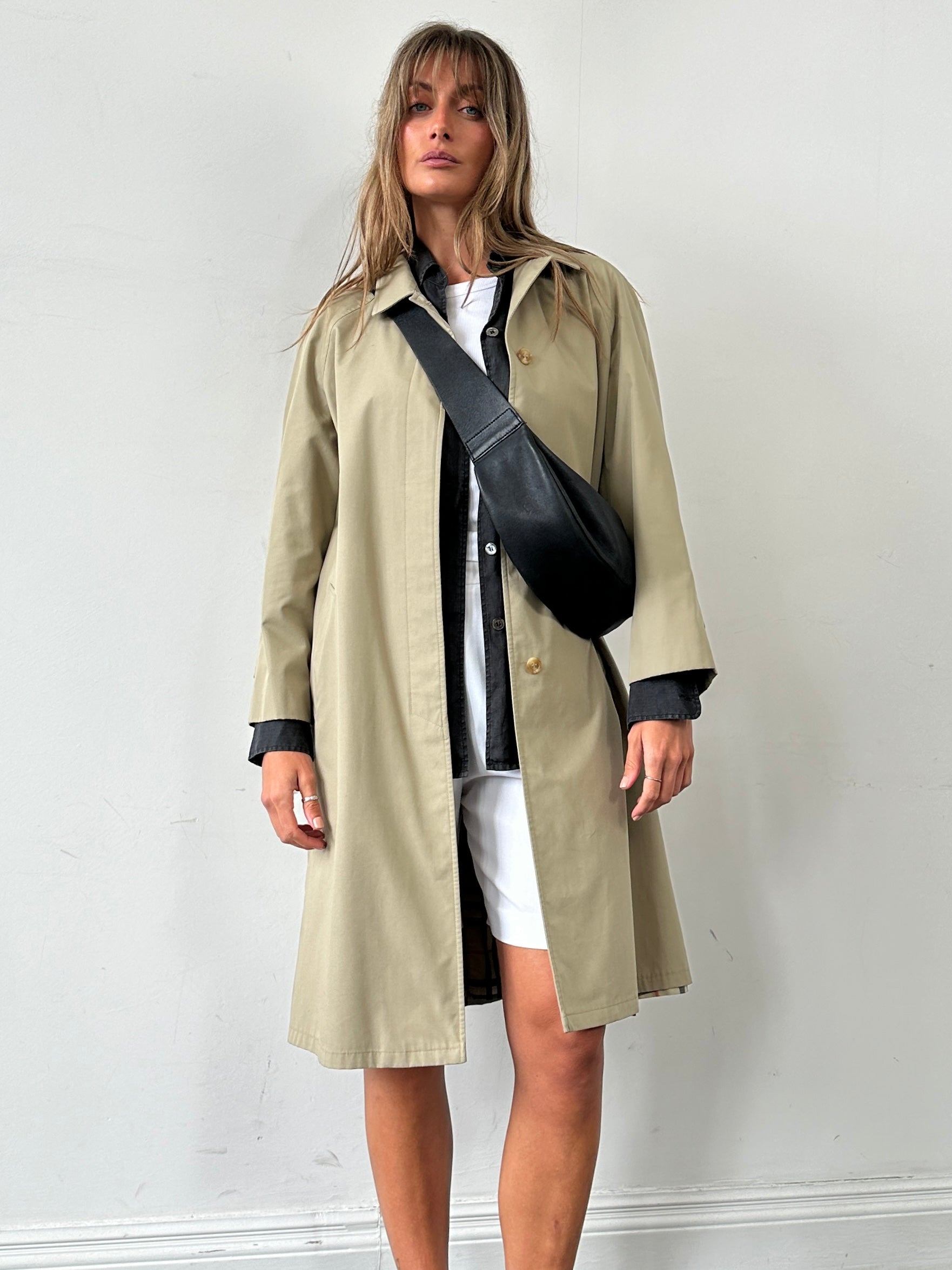 Vintage showerproof belted trench coat in size M, featuring classic design and durable fabric, suitable for rain protection.