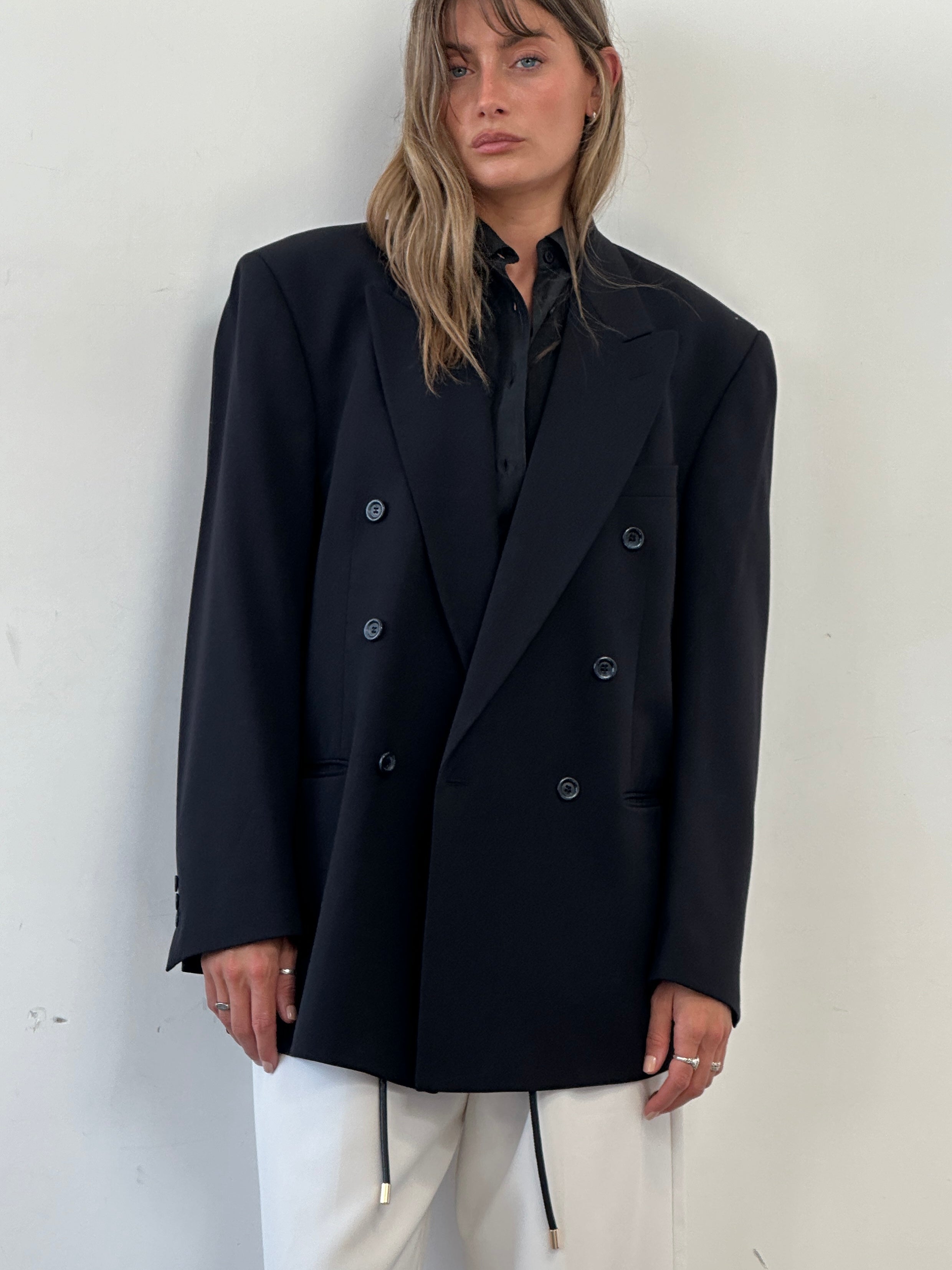 Vintage double-breasted wool blazer in XL size, tailored fit with classic lapels and textured fabric, displayed on a hanger.