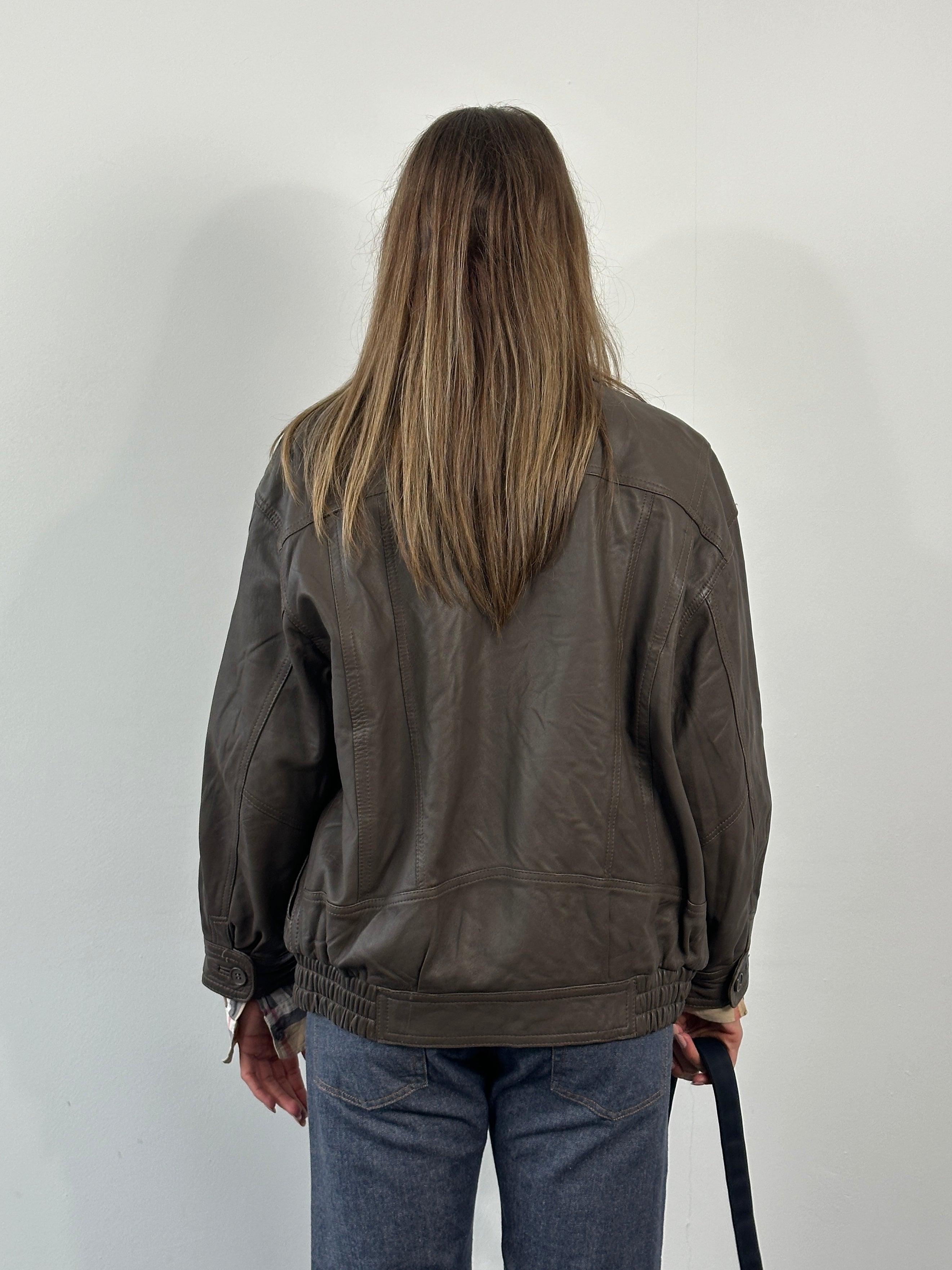 Vintage 1990s leather bomber jacket in size M, featuring classic design with front zipper and ribbed cuffs.