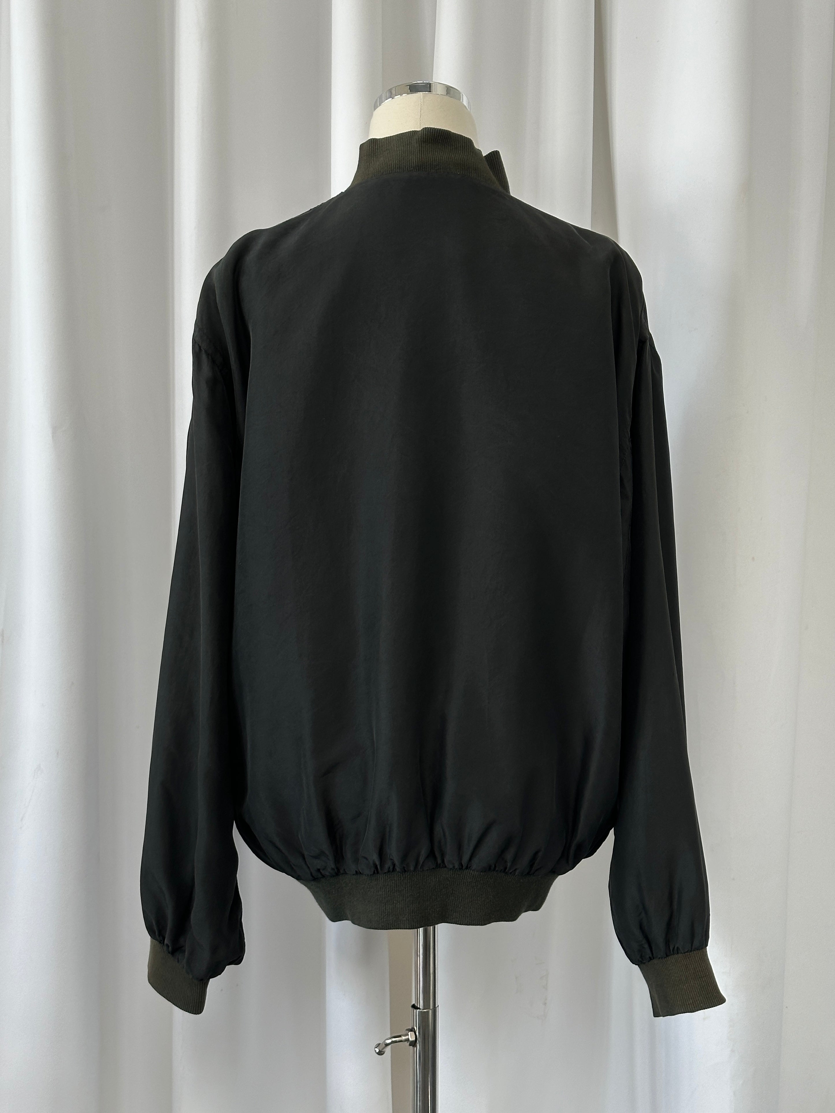 Vintage 1990s pure silk bomber jacket, M/L, with retro style and smooth fabric, shown on a hanger against a neutral background.