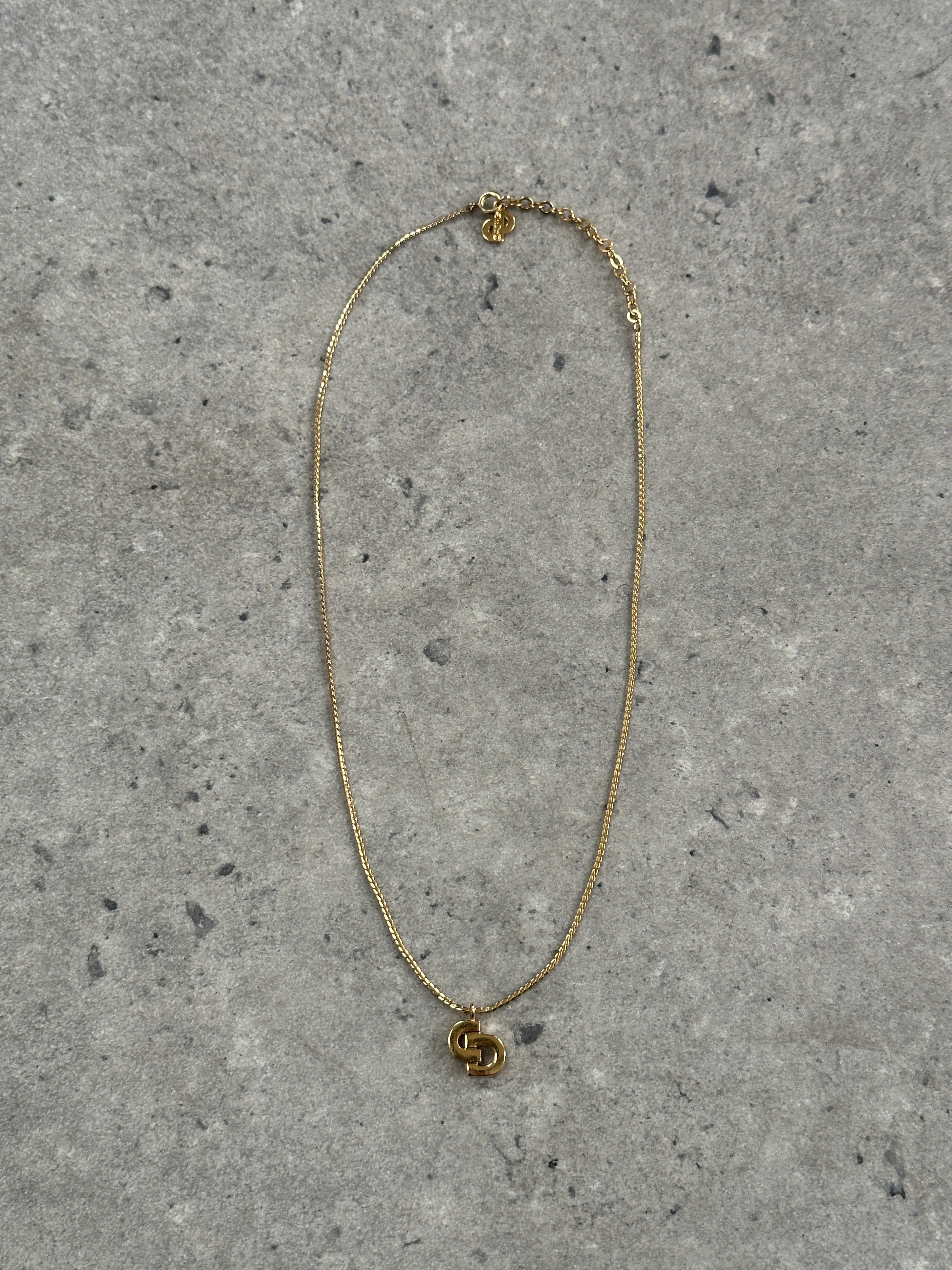 Christian Dior gold plated logo pendant necklace, 16-inch chain with iconic Dior branding and sleek design.