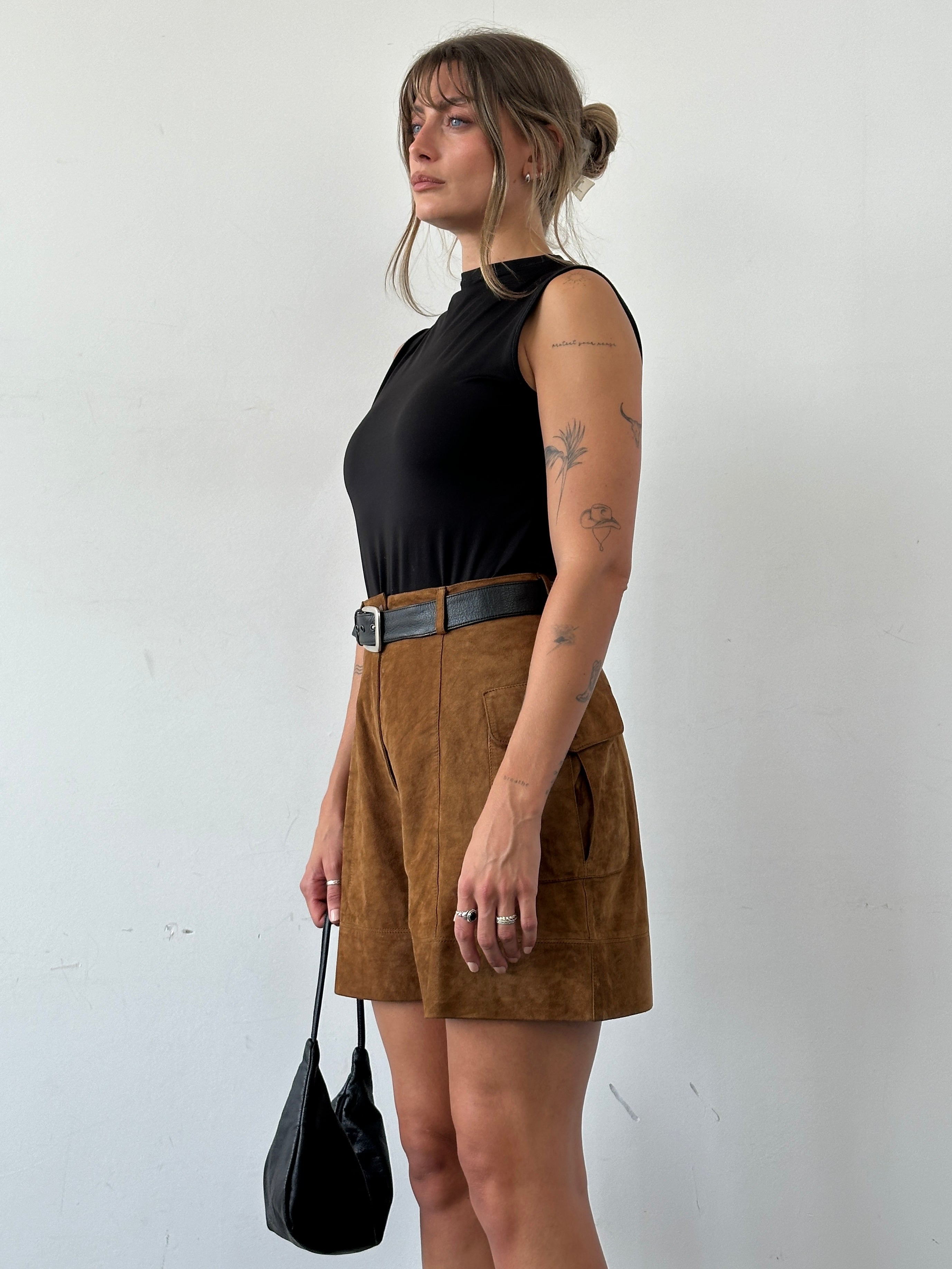 Vintage Italian high waisted suede leather shorts, size W27, featuring a classic retro style and soft textured material.
