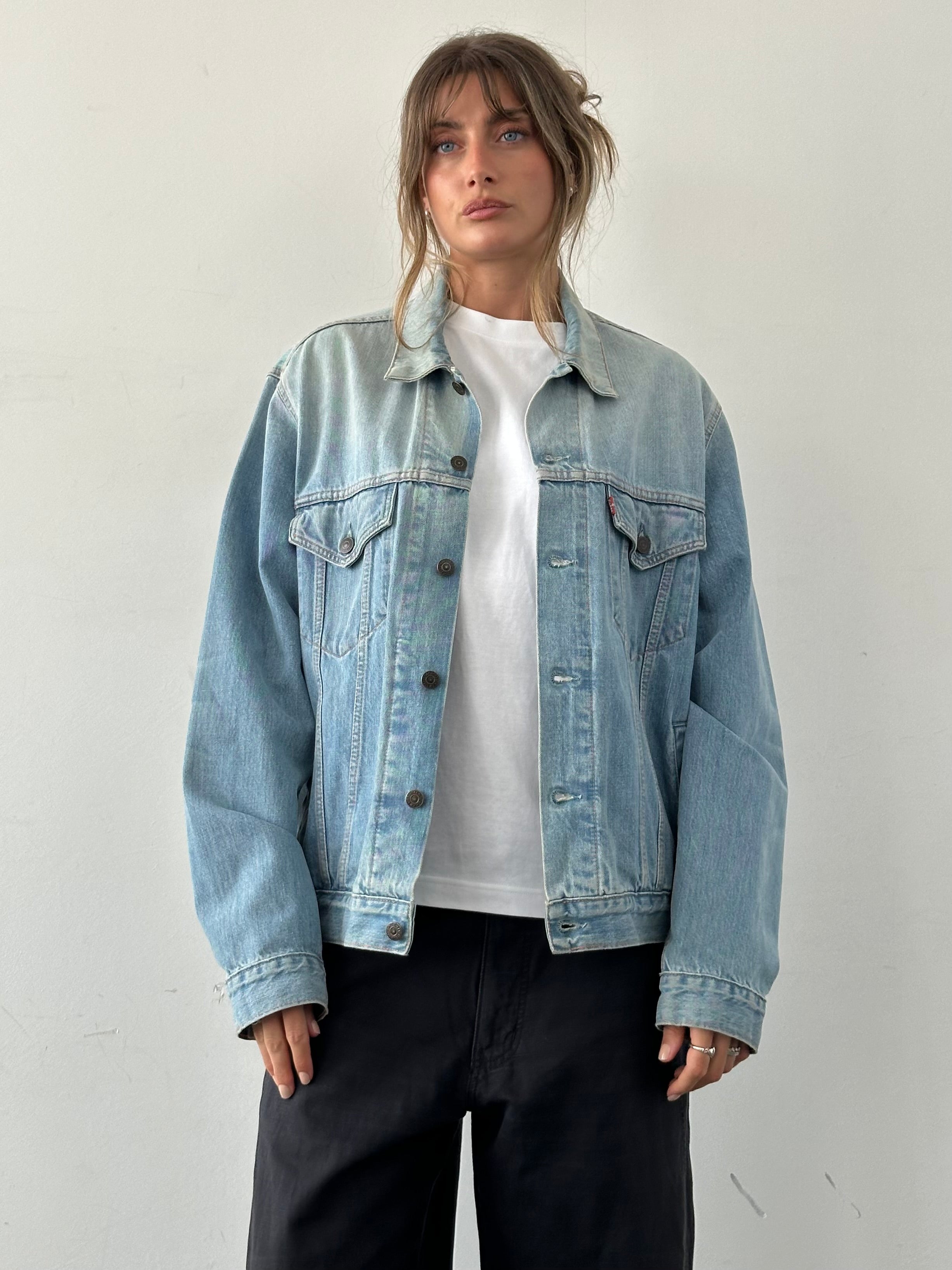 Levi’s faded denim jacket in size L displayed on a hanger, showcasing classic casual style and distressed denim texture.