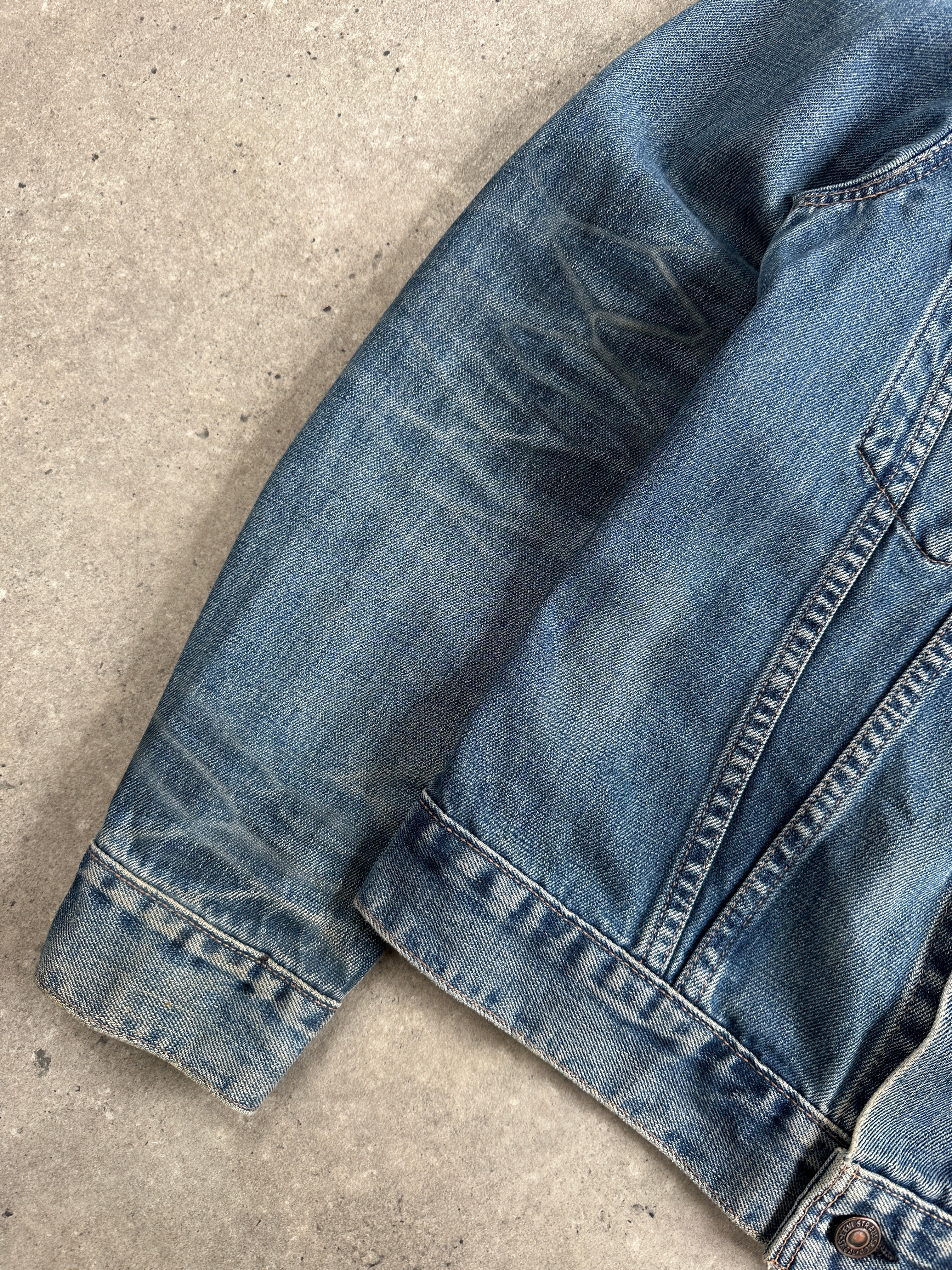 Levi’s 1990s faded denim jacket with classic design, shown in a front view, size medium, featuring a worn-in denim look.