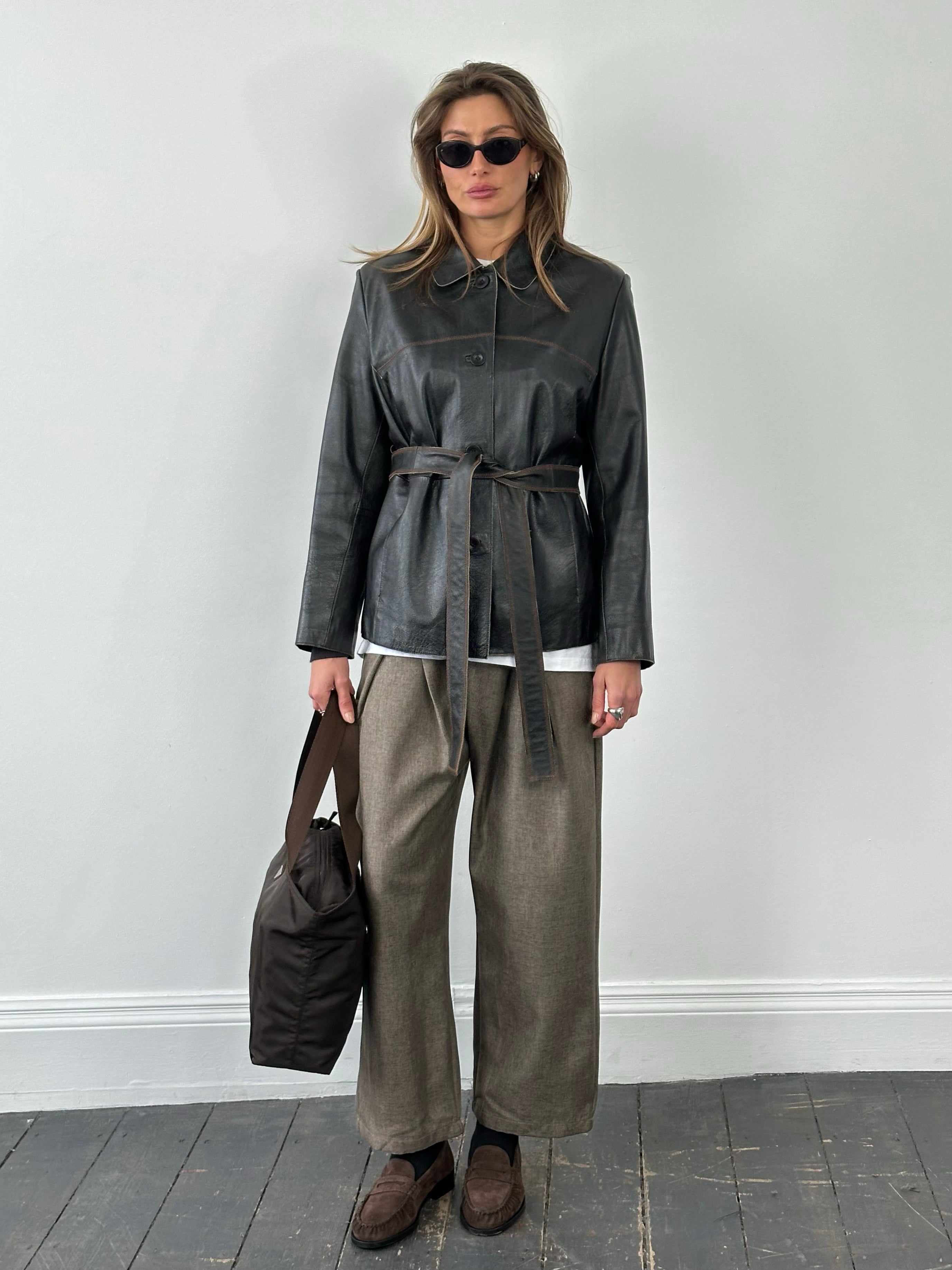 Vintage 1990s leather belted jacket, size small, featuring classic leather material and retro style, shown on a hanger.