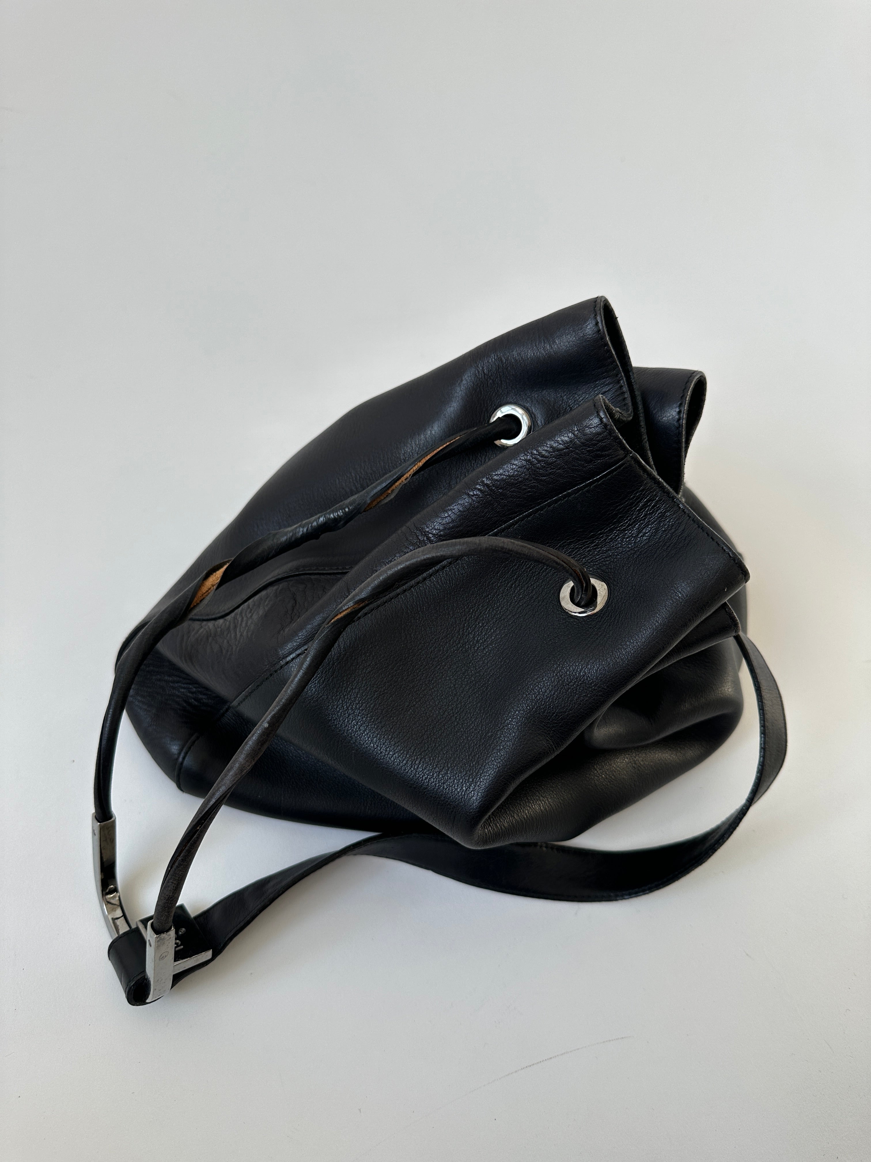 Gucci leather bucket bag with adjustable strap and gold-tone hardware, stylish and versatile accessory for everyday use.