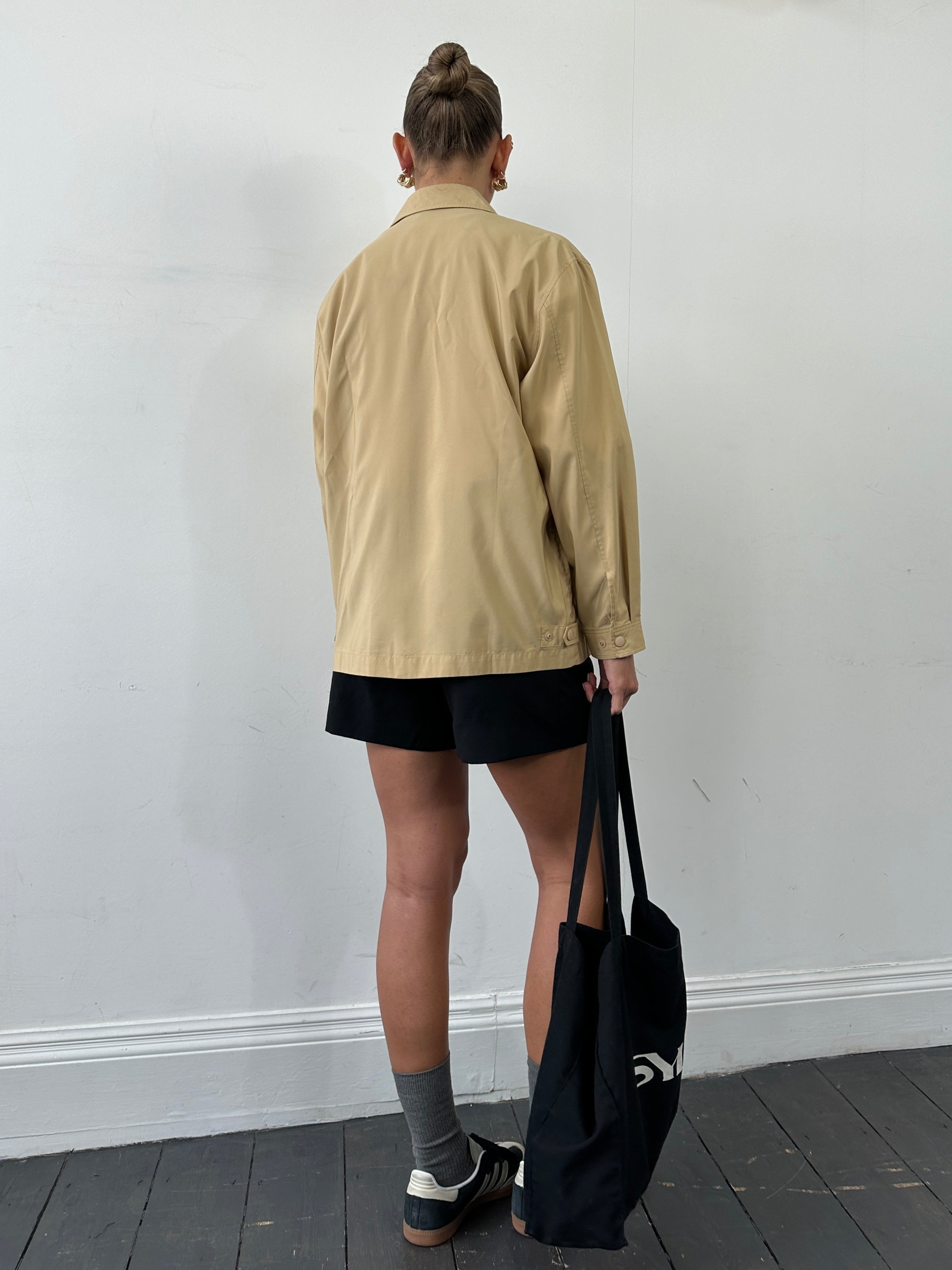 Yves Saint Laurent Pour Homme showerproof logo bomber jacket in large size, black with YSL branding, displayed on a hanger.