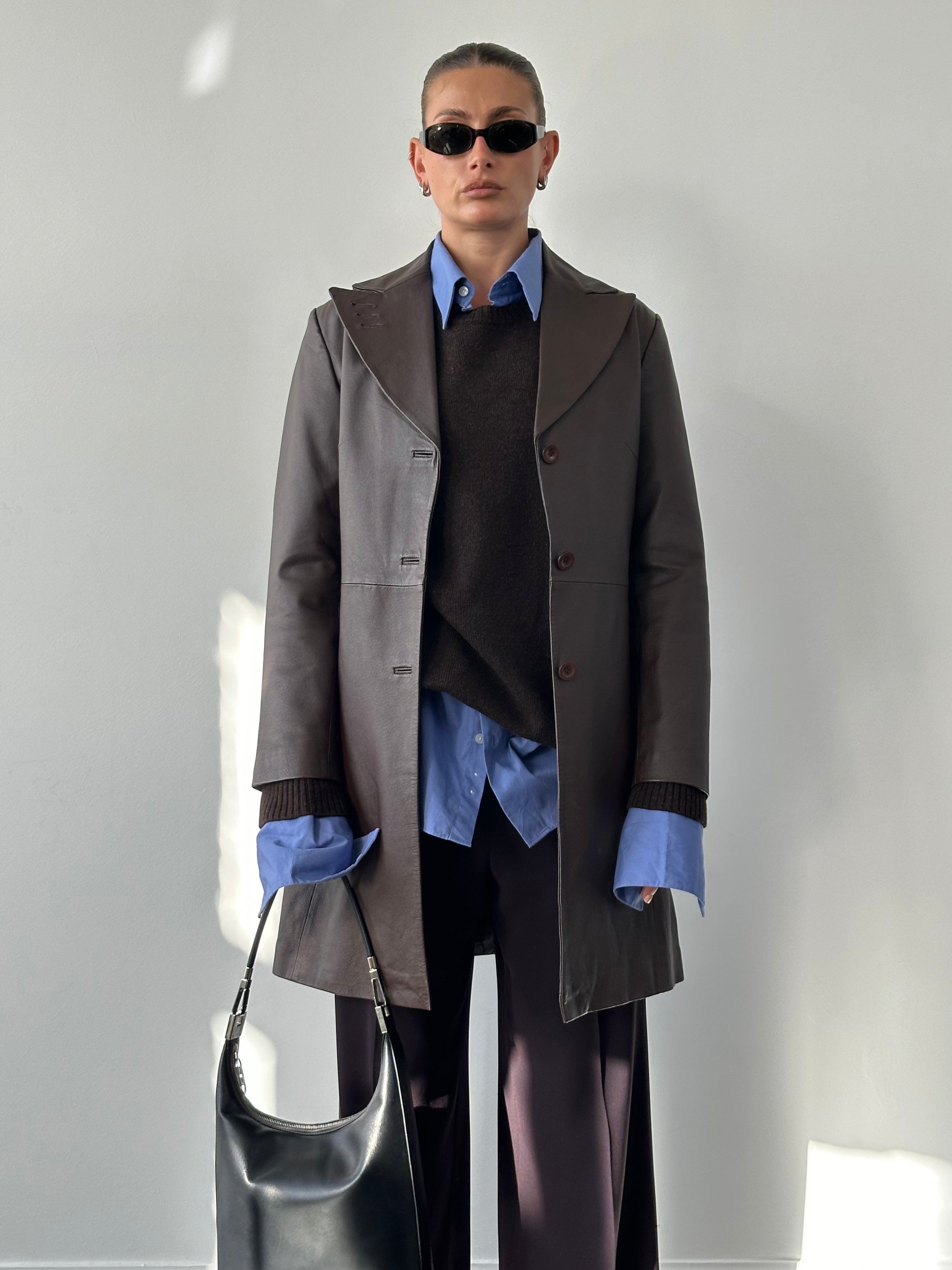 Vintage leather trench coat jacket in size M/L, featuring classic design and durable material, displayed on a hanger.