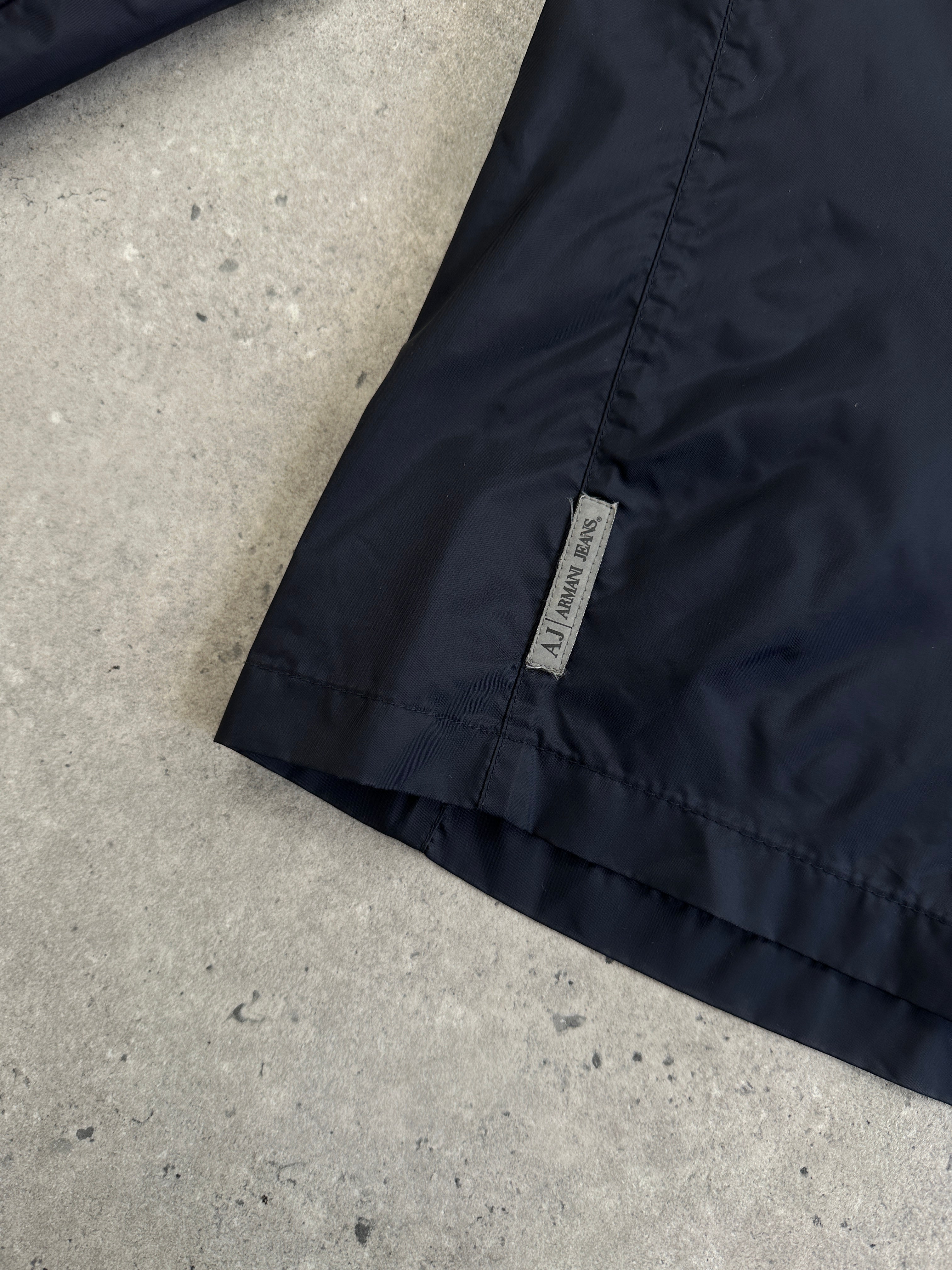 Armani Jeans 1990s lightweight nylon showerproof jacket with logo, shown in black with front zipper and hood.
