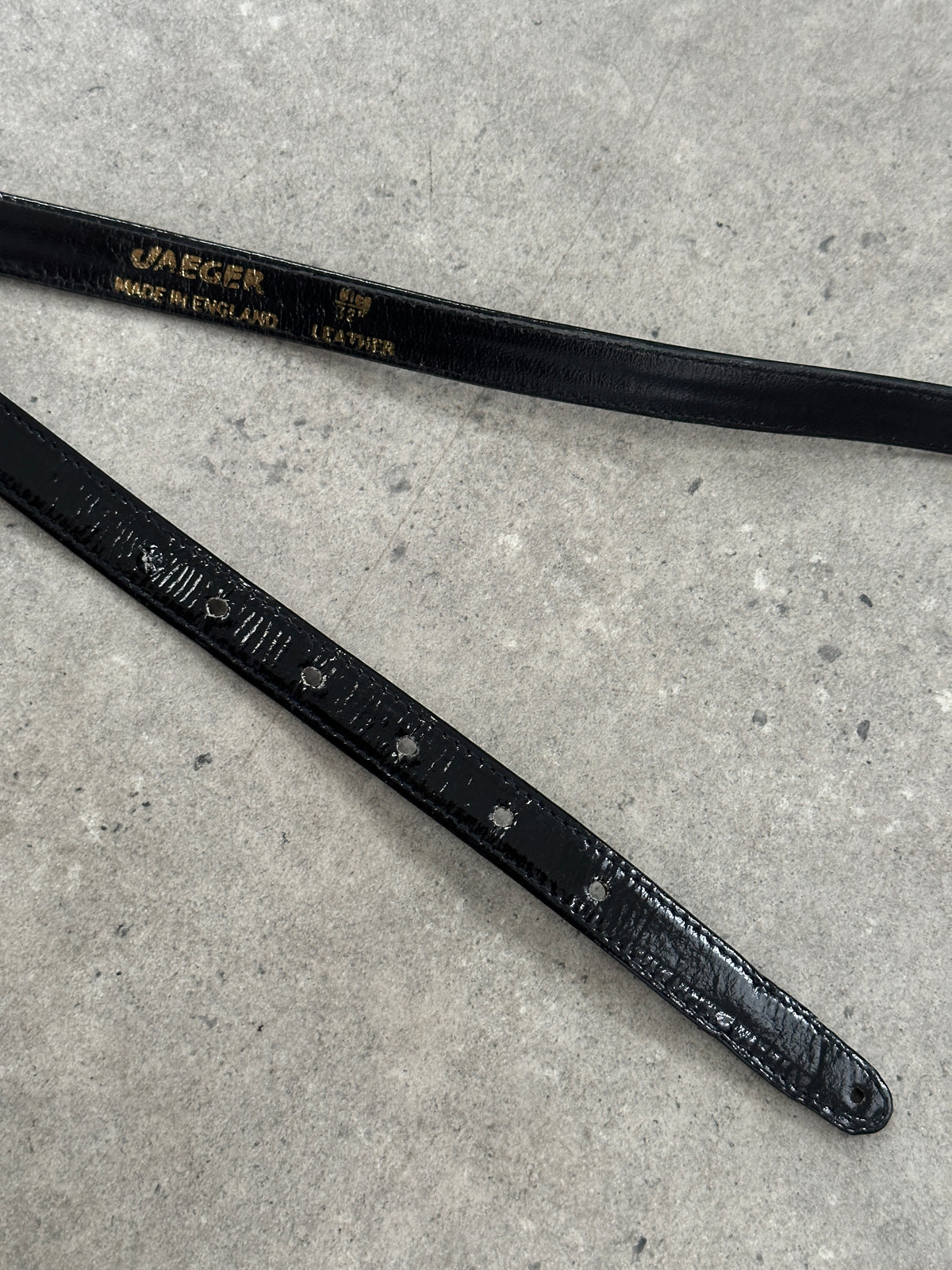 Jaeger 1990s patent leather sculptural buckle belt in size W30-35, featuring bold metallic buckle and sleek black finish.