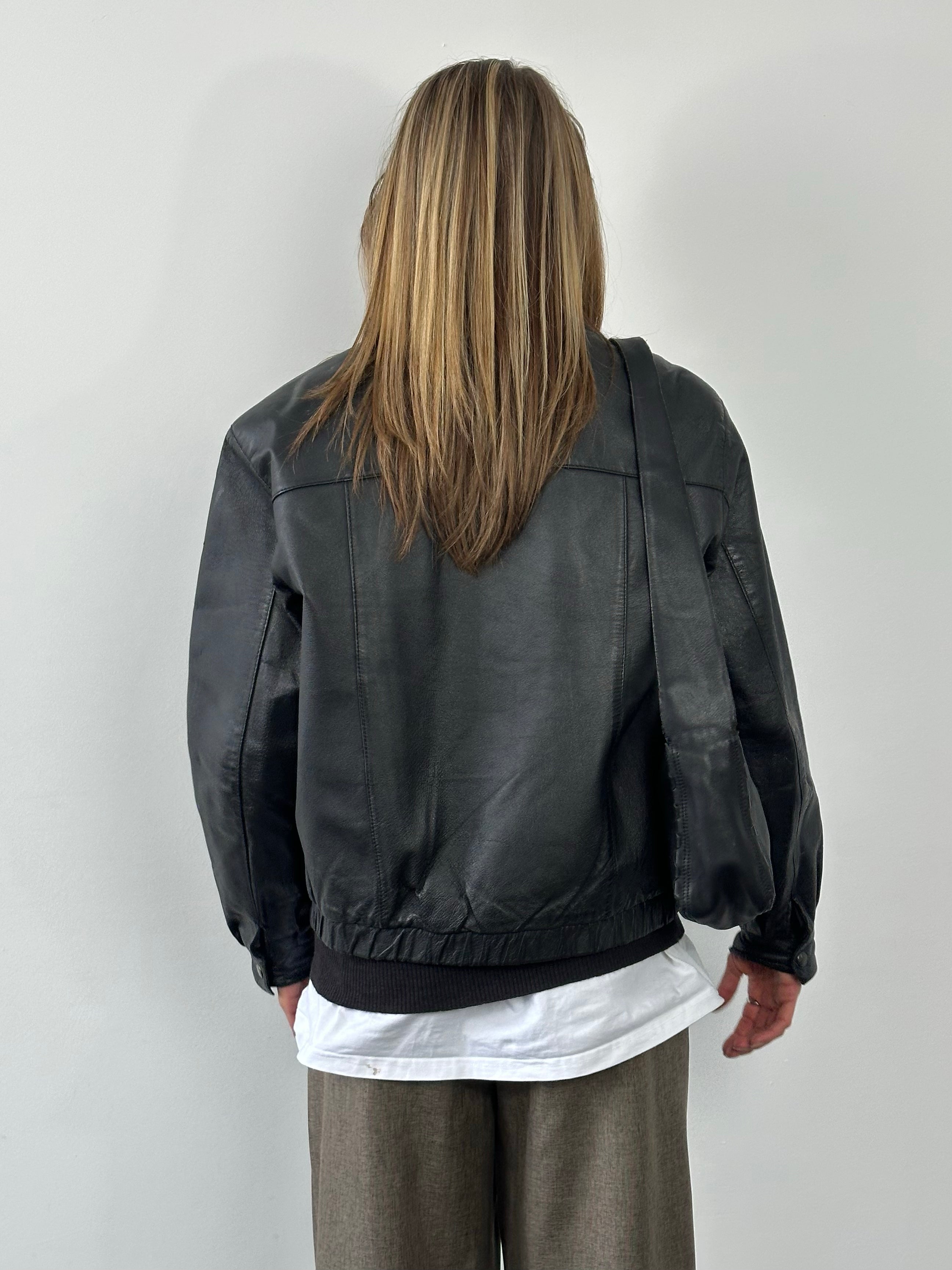 Vintage 1990s minimal leather jacket in size M, featuring classic design and smooth leather material.