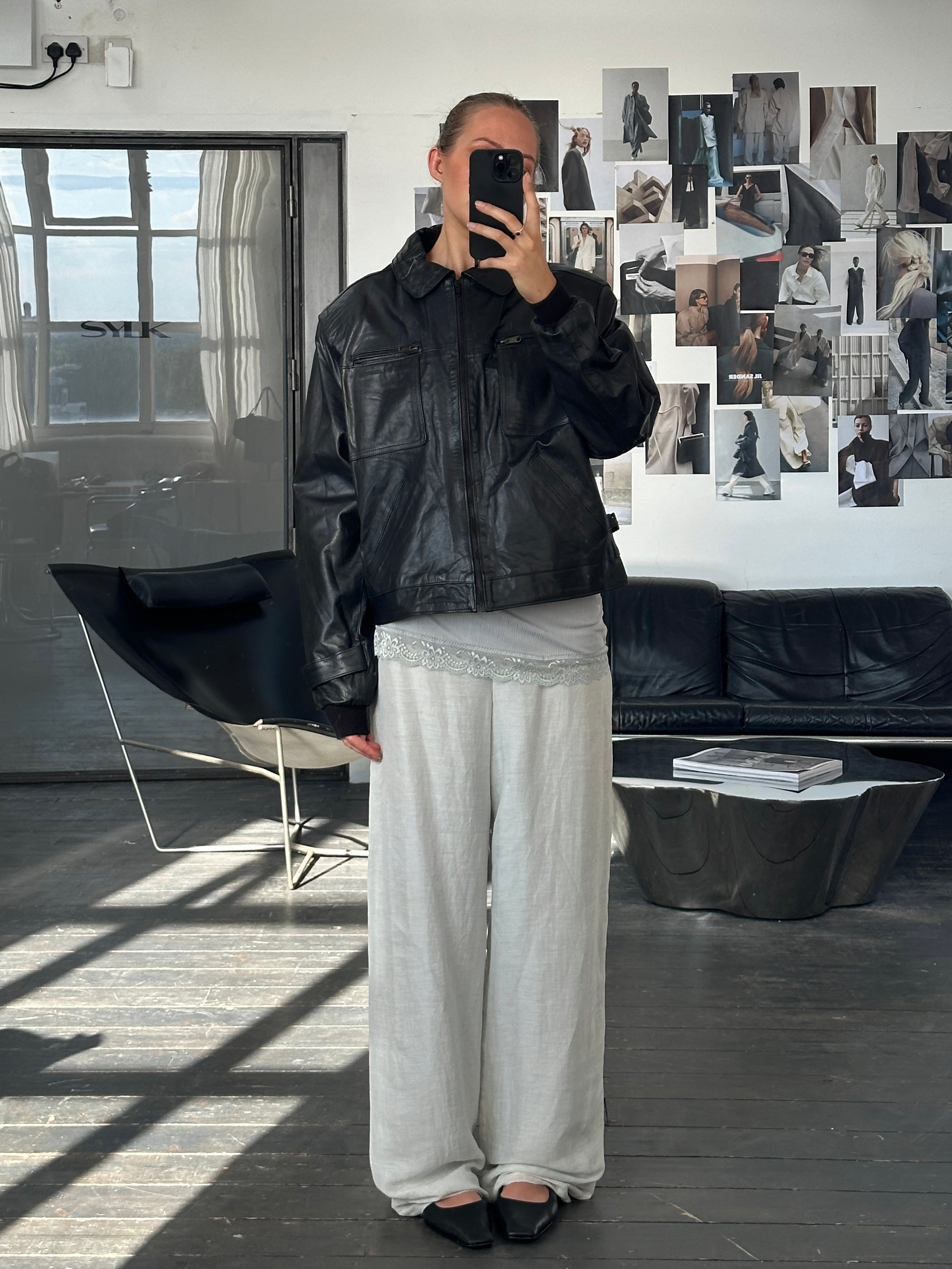 Vintage 1990s boxy cropped leather jacket in black, with a classic collar and silver button details.