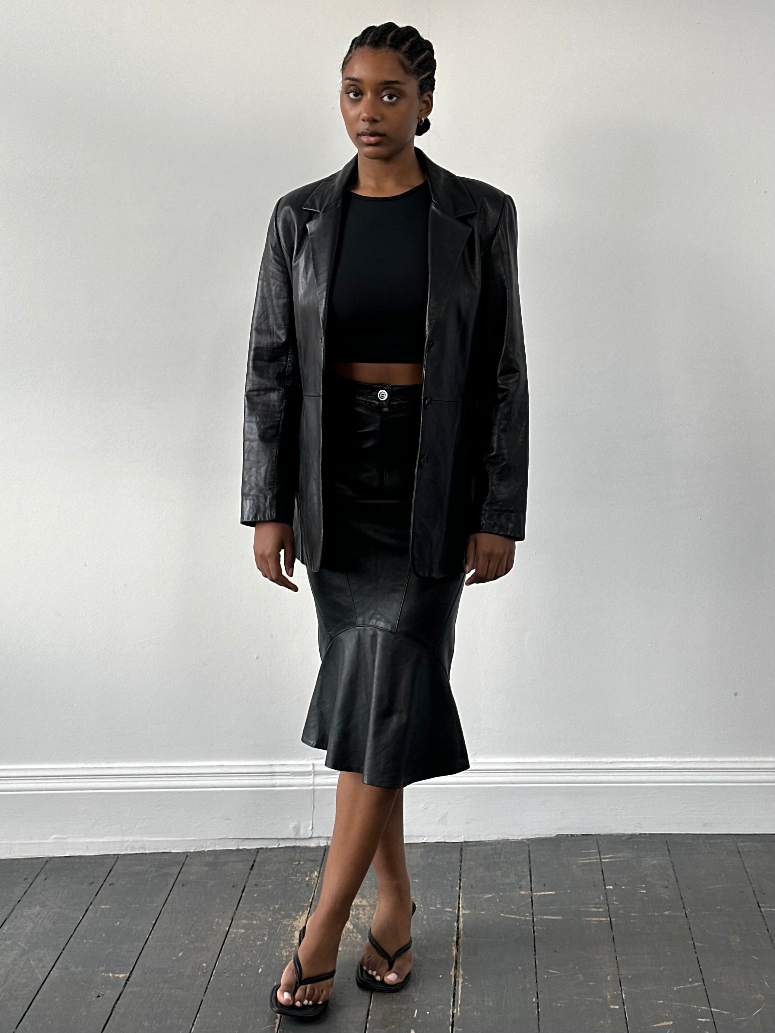 Vintage 1990s leather midi skirt, stylish and classic, featuring a sleek design with a high waist and knee-length cut.