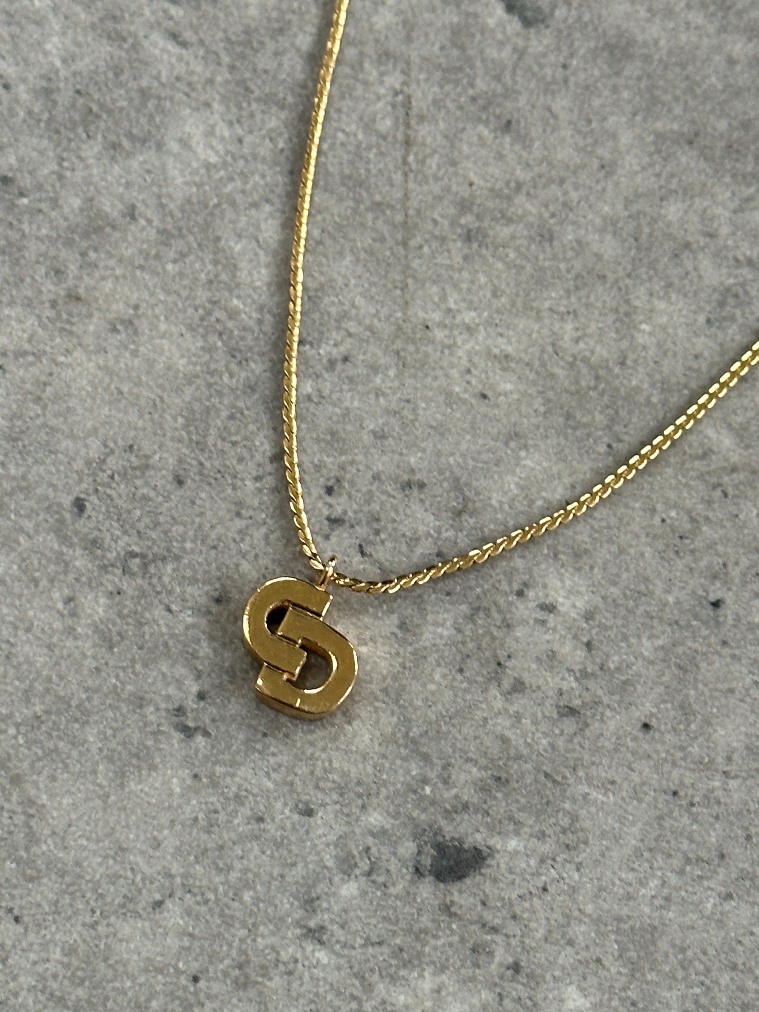 Christian Dior gold plated logo pendant necklace, 16-inch chain, featuring the iconic Dior logo charm on a sleek gold finish.