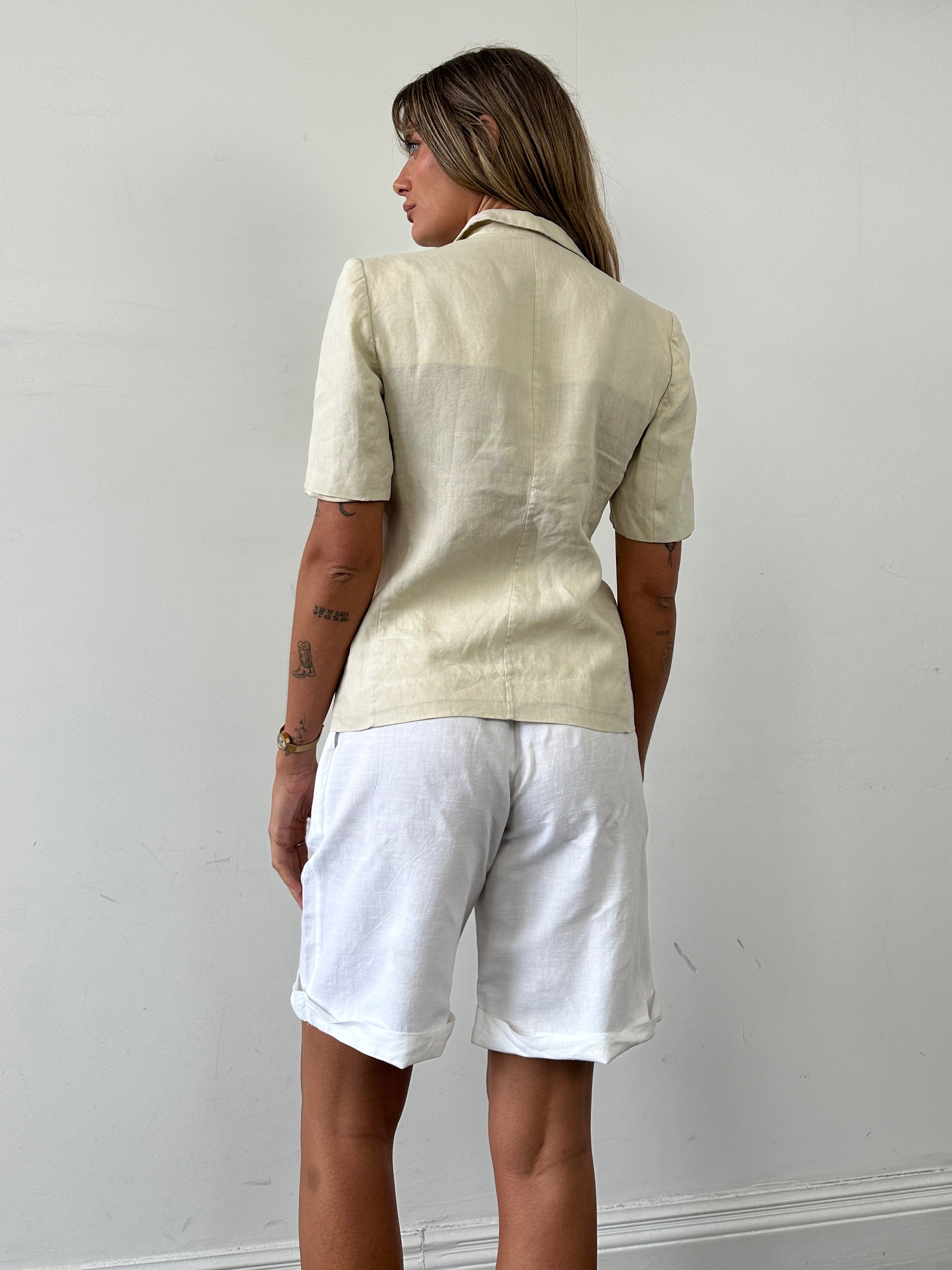 Max Mara pure linen short sleeve blazer in S/M displayed on a hanger, showcasing its tailored fit and lightweight fabric.
