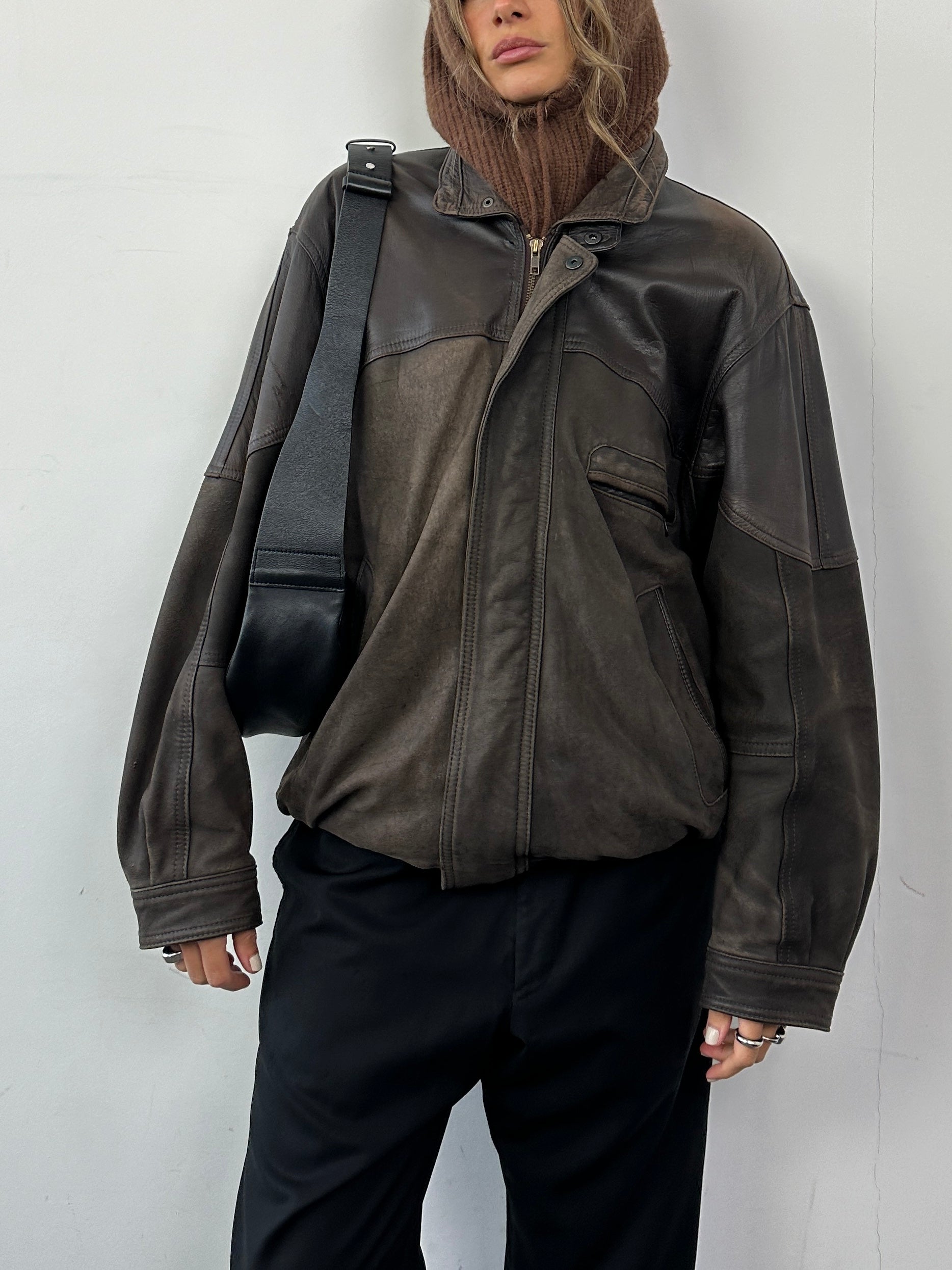 Vintage aged leather bomber jacket in size large, featuring classic design with distressed leather and ribbed cuffs.