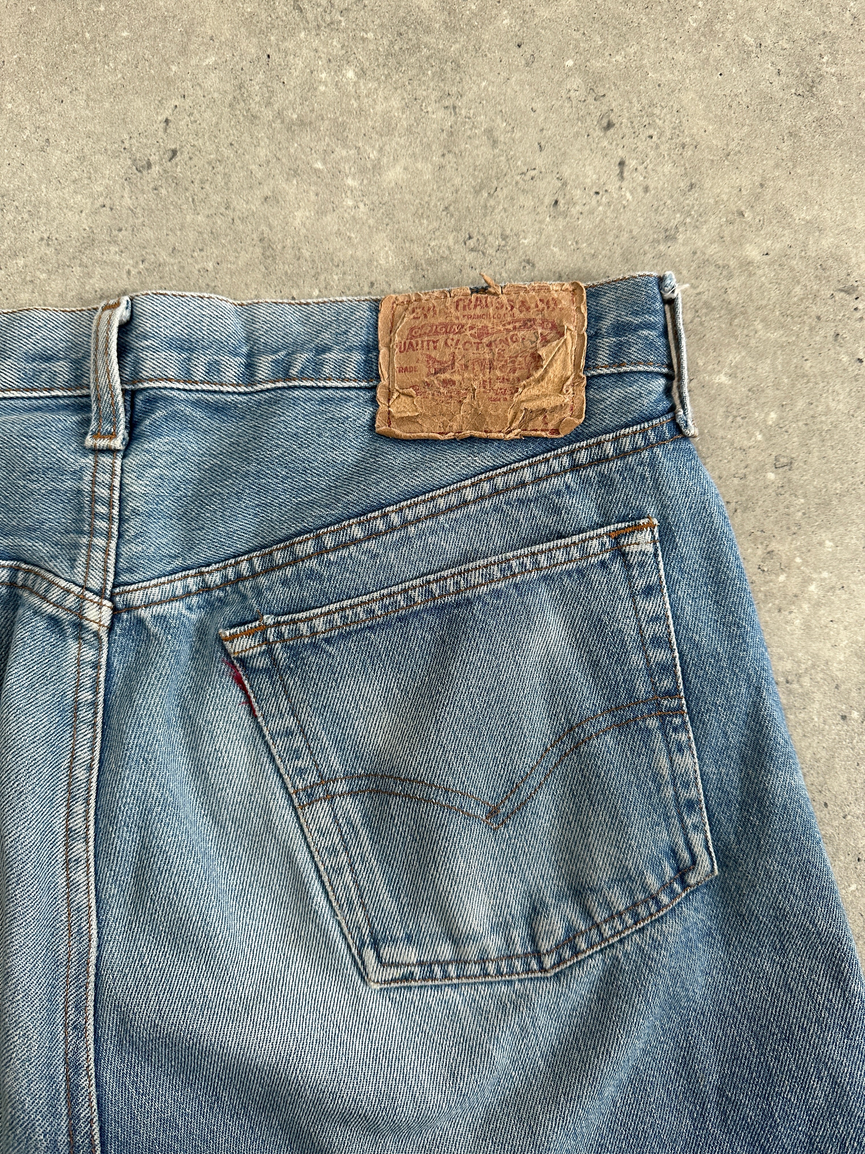 Levi's 501 straight leg denim jeans in W32, classic blue wash, shown folded with visible stitching and durable denim fabric.