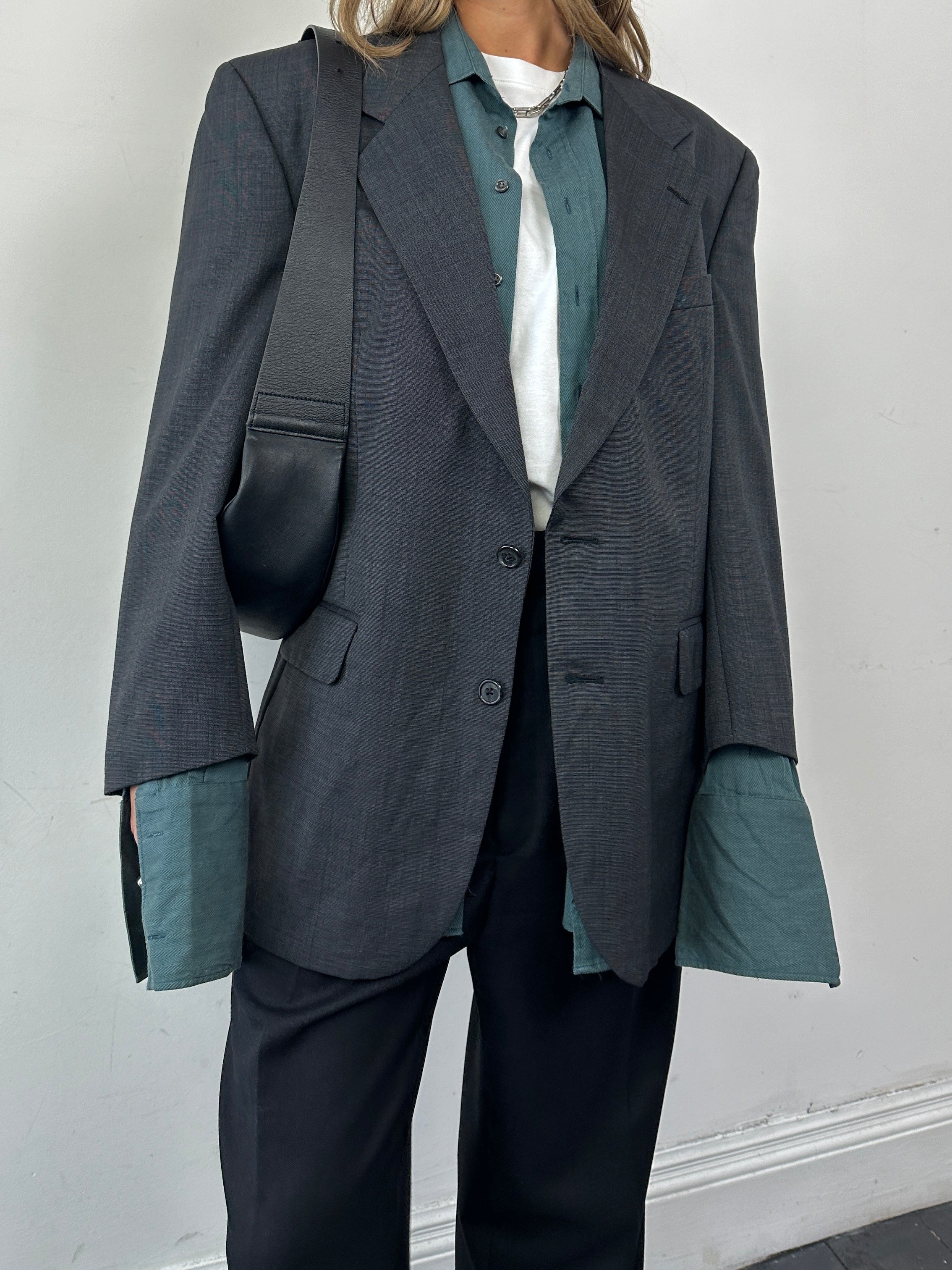 Christian Dior Le Connaisseur pure wool single-breasted blazer in dark color, displayed on a hanger.
