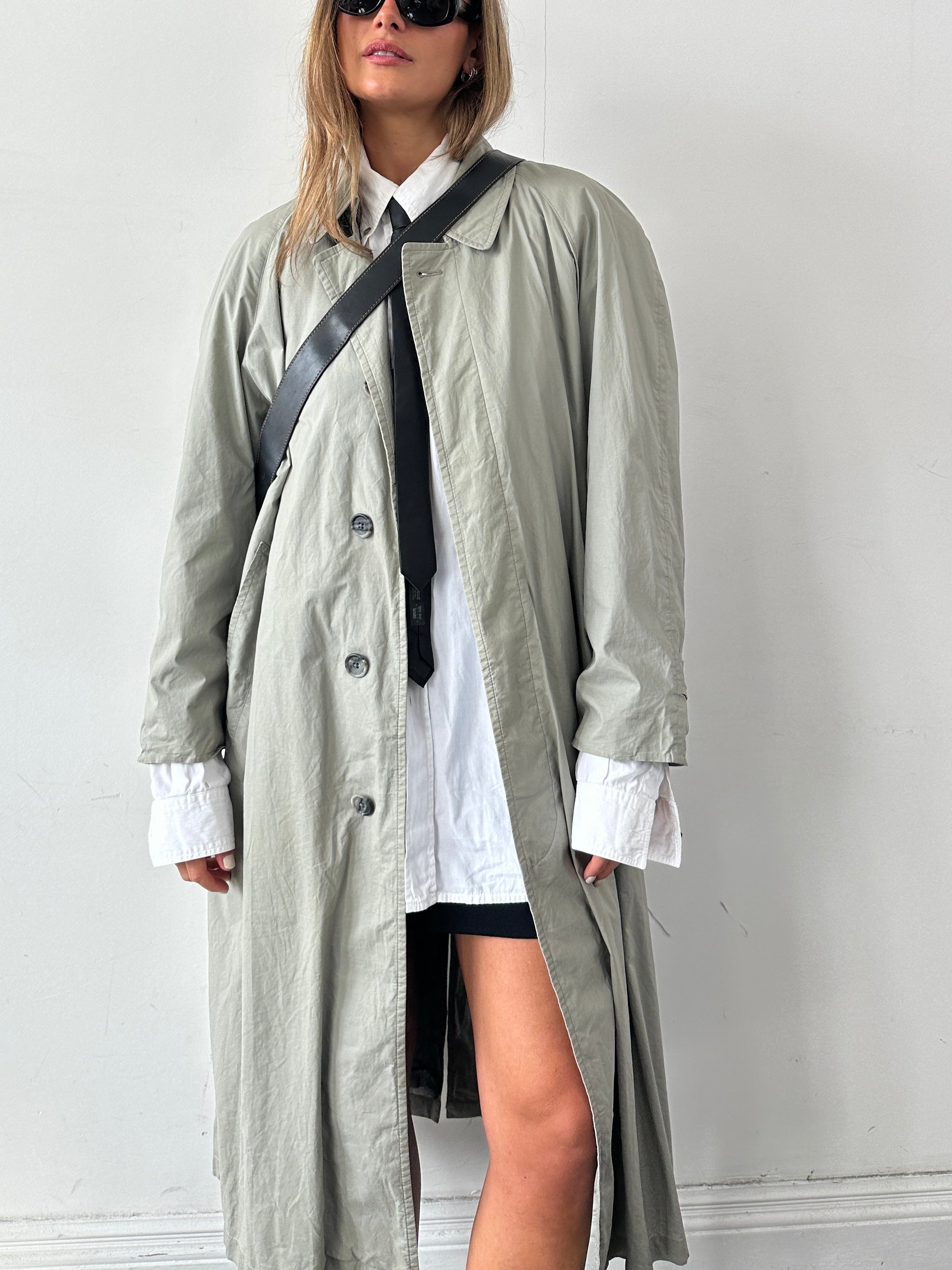Christian Dior Le Connaisseur belted trench coat in beige, tailored fit with classic double-breasted design and belt at waist.