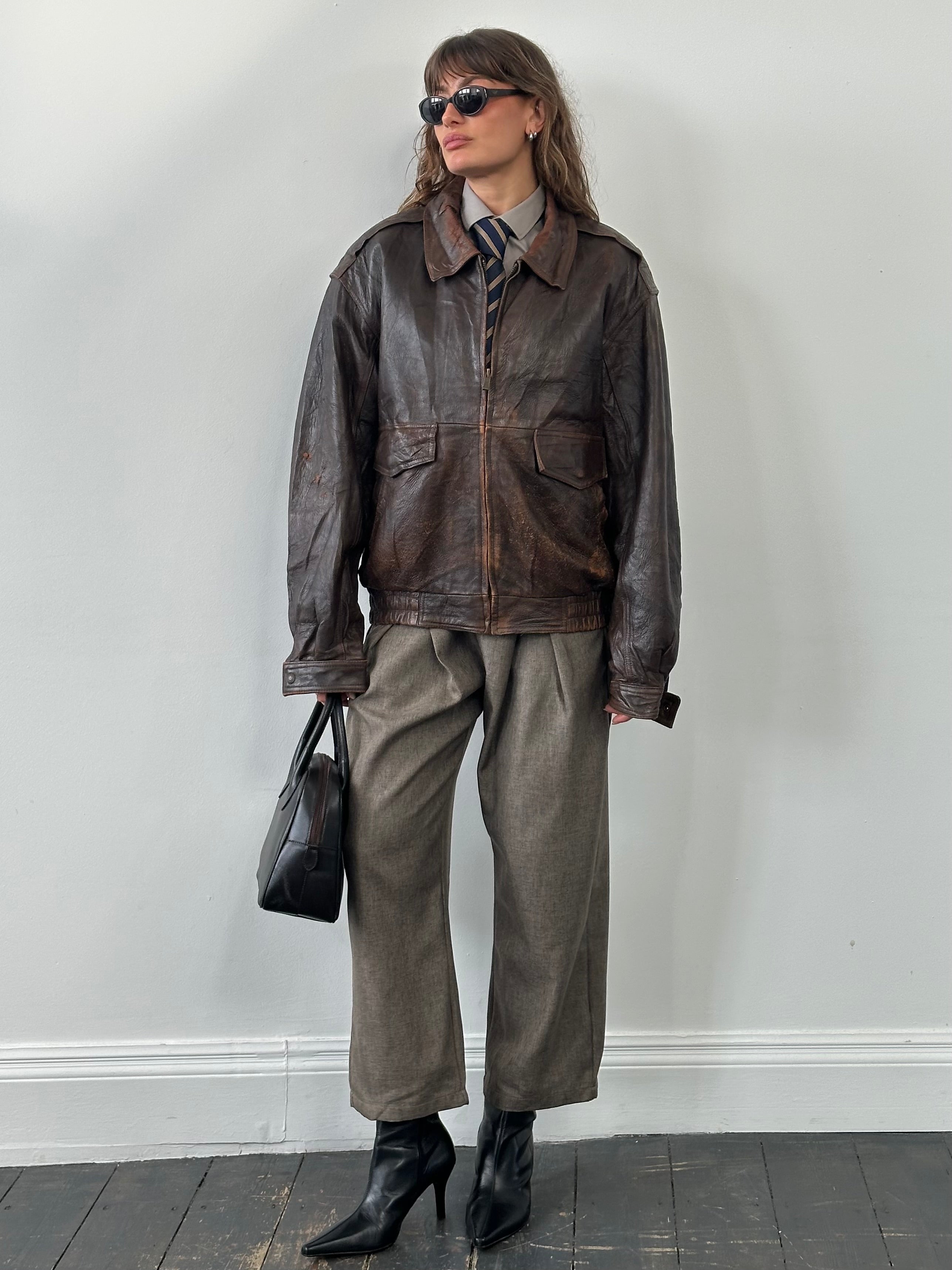 Vintage 1990s distressed leather bomber jacket in XL, showcasing rugged texture and classic style.