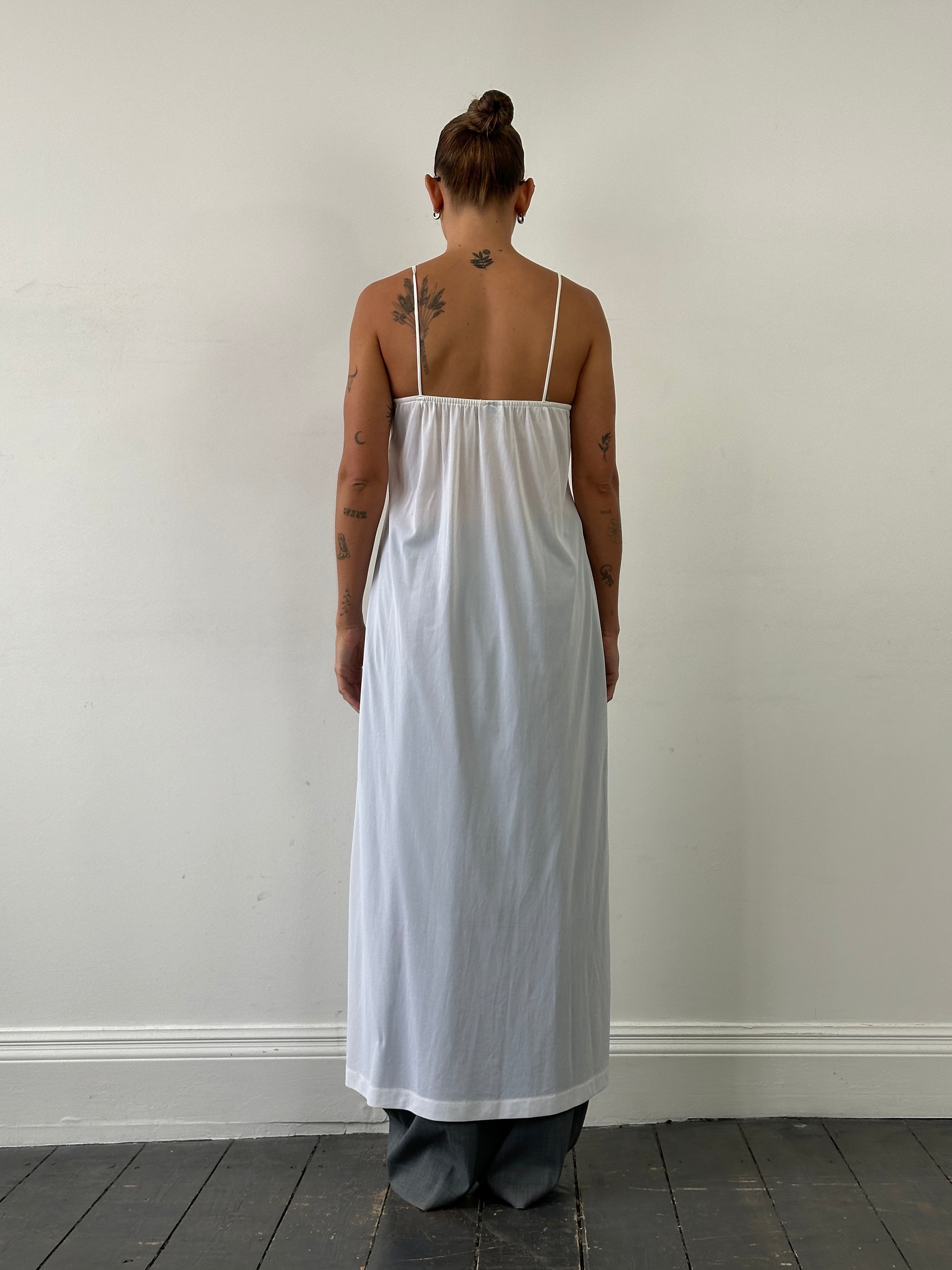 Vintage sheer maxi slip dress in size S/M displayed on a hanger, featuring a flowing, lightweight fabric and elegant design.