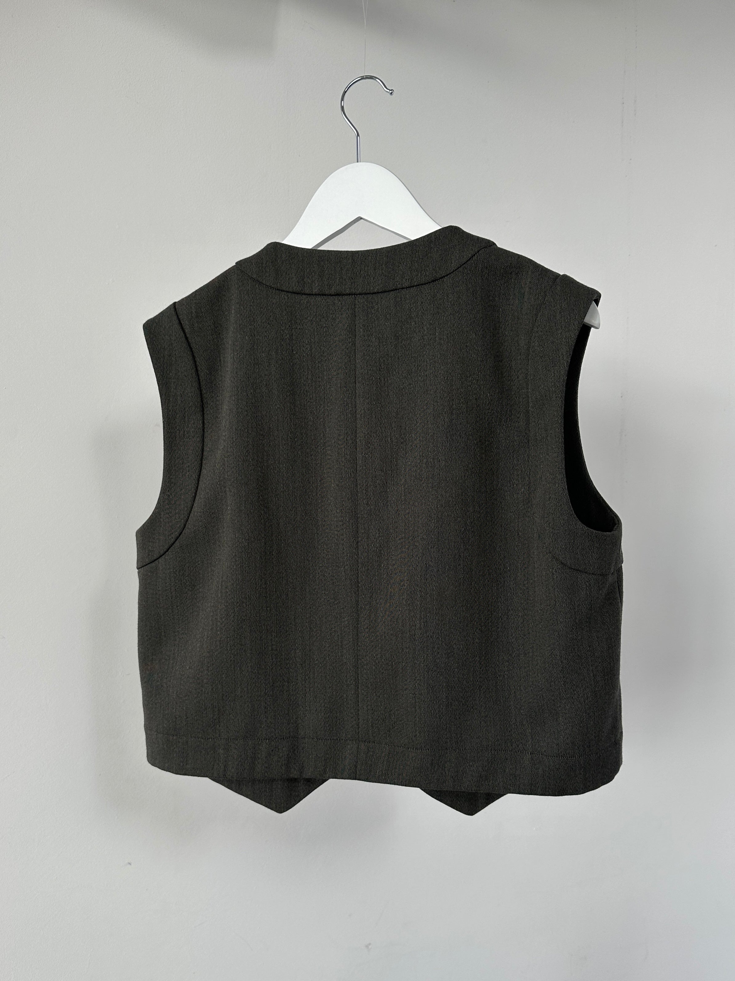 Mani Wool Waistcoat in size L, stylish sleeveless outerwear with a wool blend fabric, displayed on a hanger.