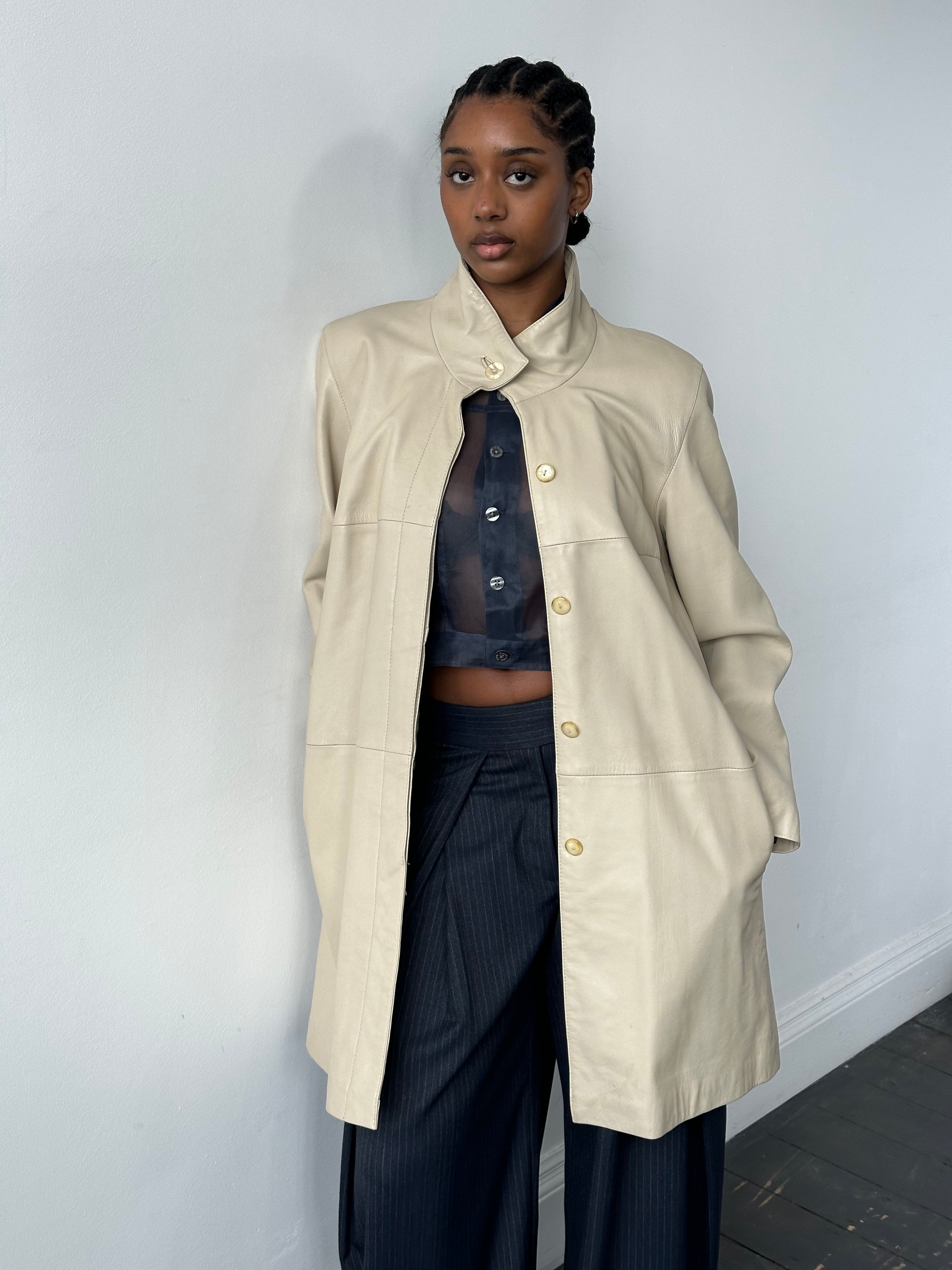 Vintage 1990s high neck leather trench coat, leather jacket with classic design, in size M/L, shown on a hanger.
