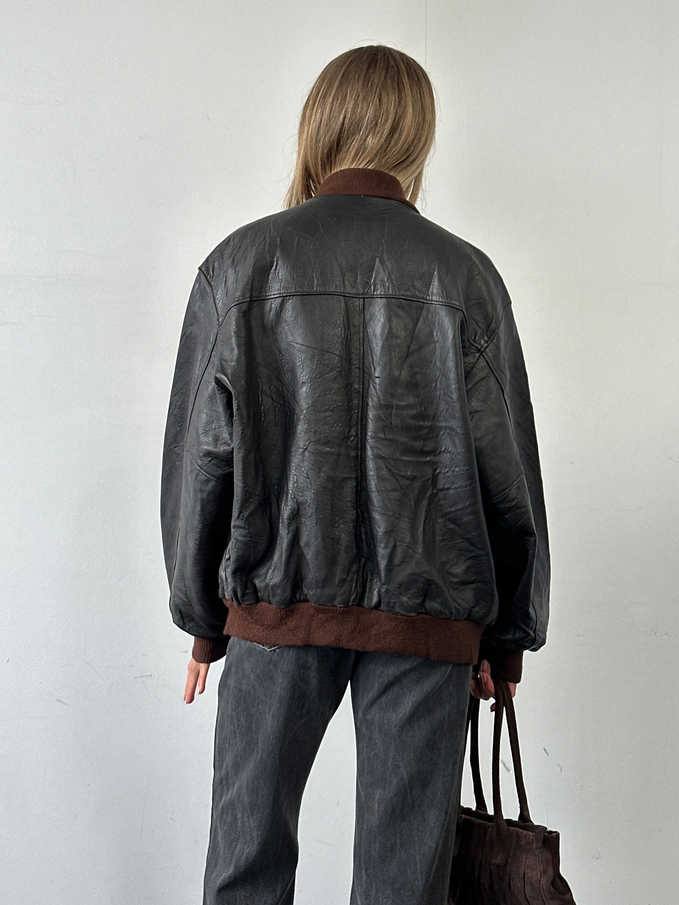 Vintage Italian vintage aged leather bomber jacket in size XL, featuring classic design and distressed leather texture.