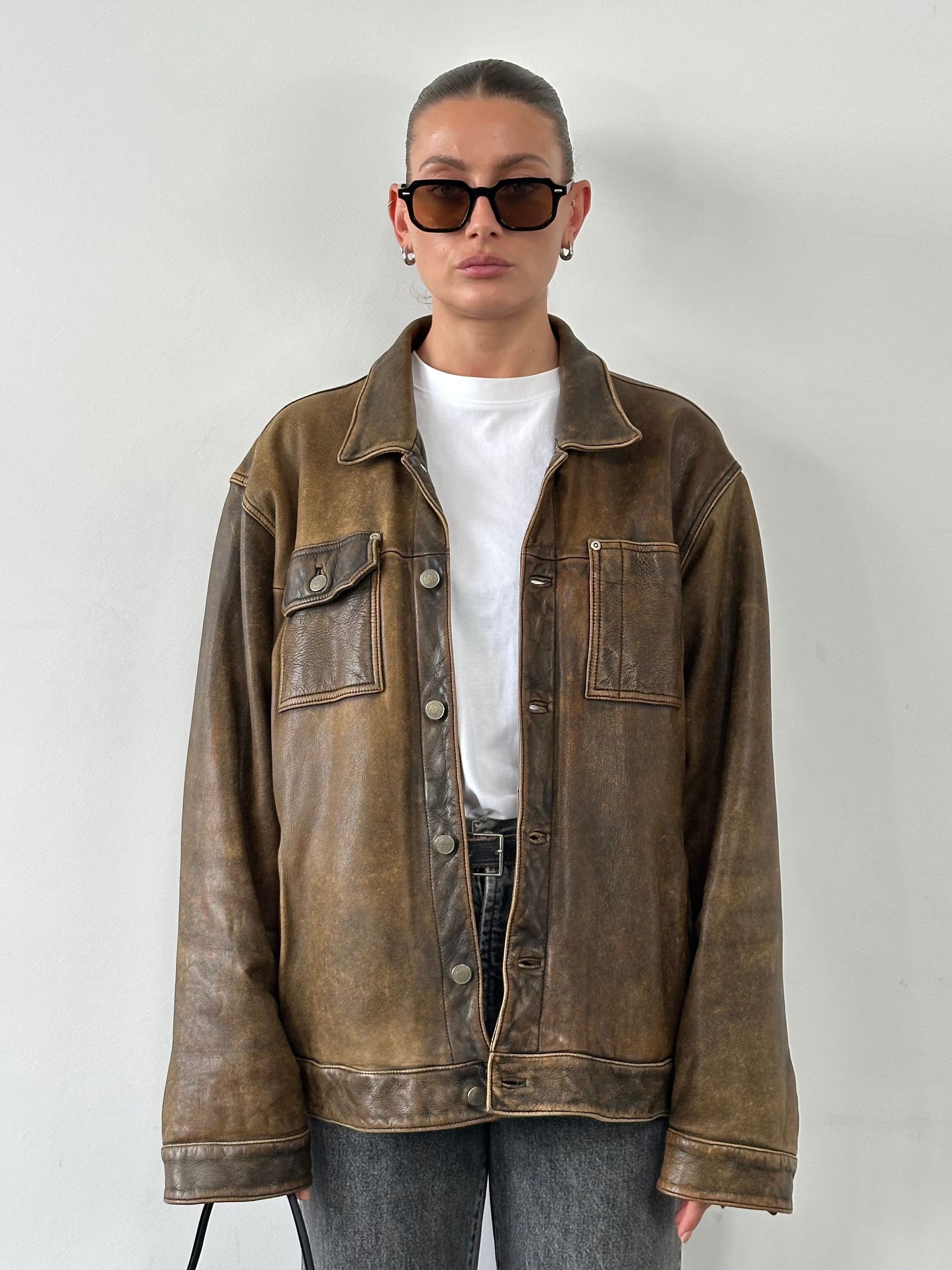 Vintage brand vintage aged leather trucker jacket in size XL, featuring distressed leather and classic collar design.