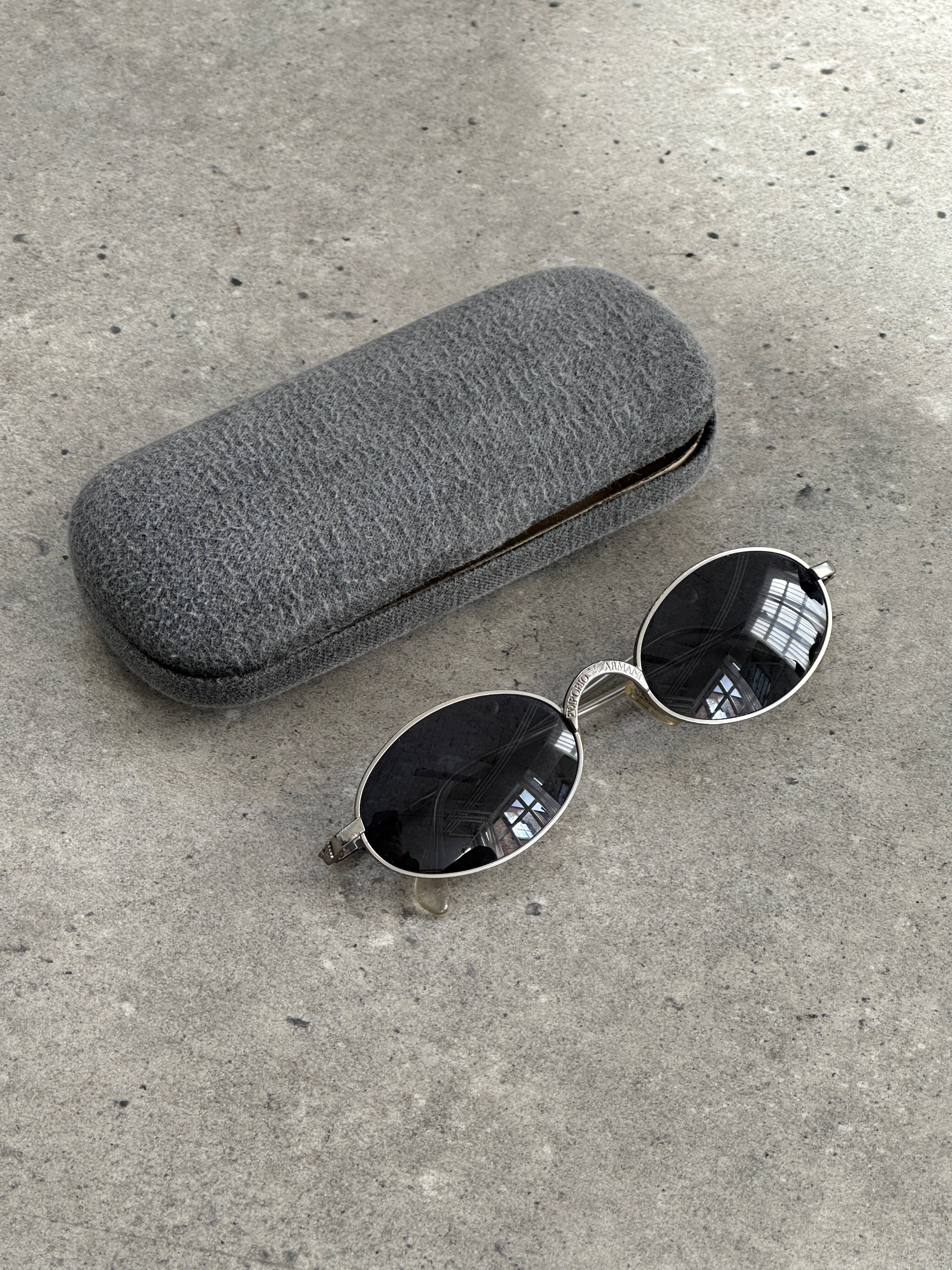 Emporio Armani metal oval sunglasses with sleek frame and dark tinted lenses, stylish eyewear for a modern look.