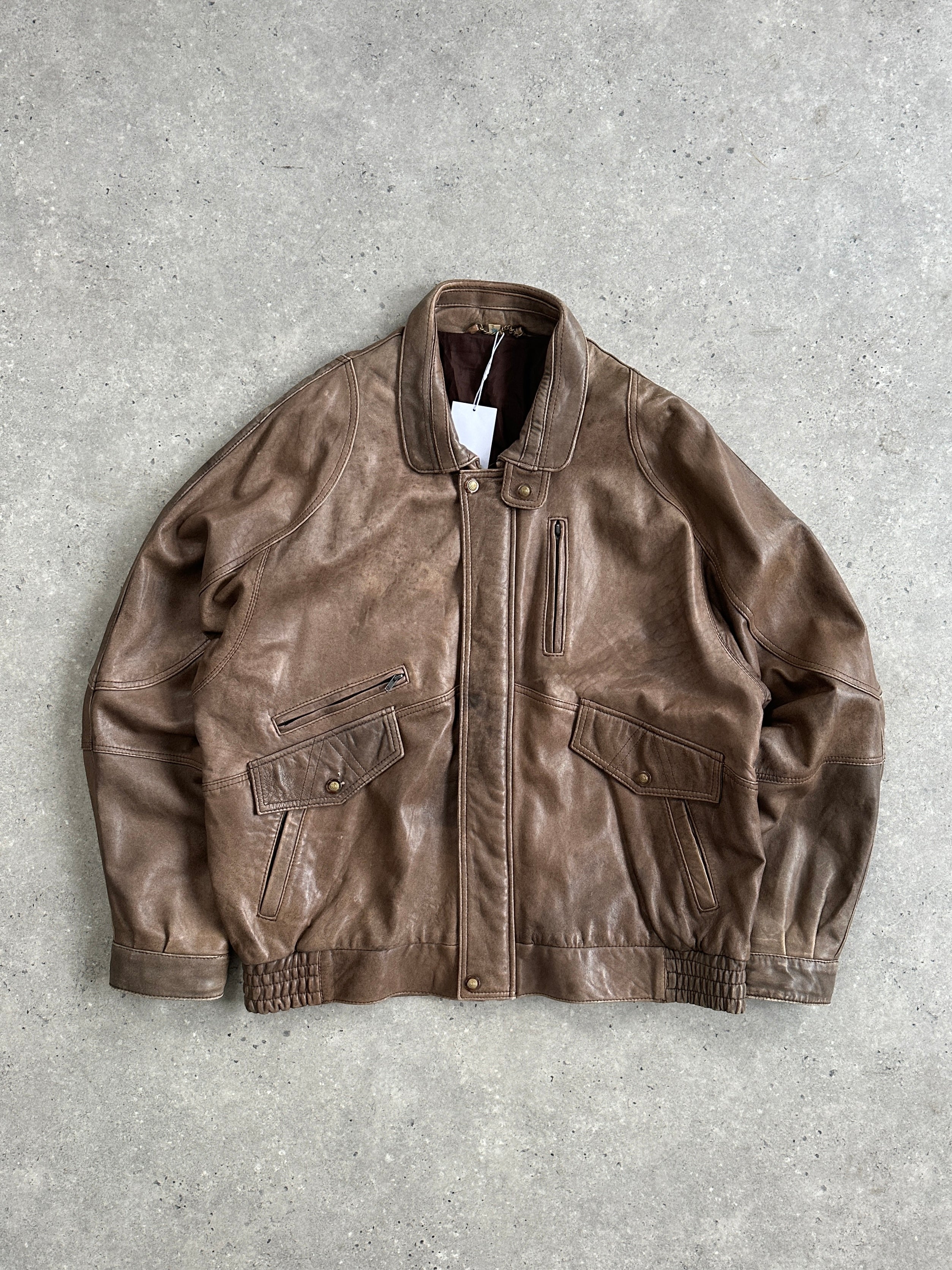 Vintage leather bomber jacket in XL/XXL, featuring classic design with a rugged leather finish and ribbed collar and cuffs.