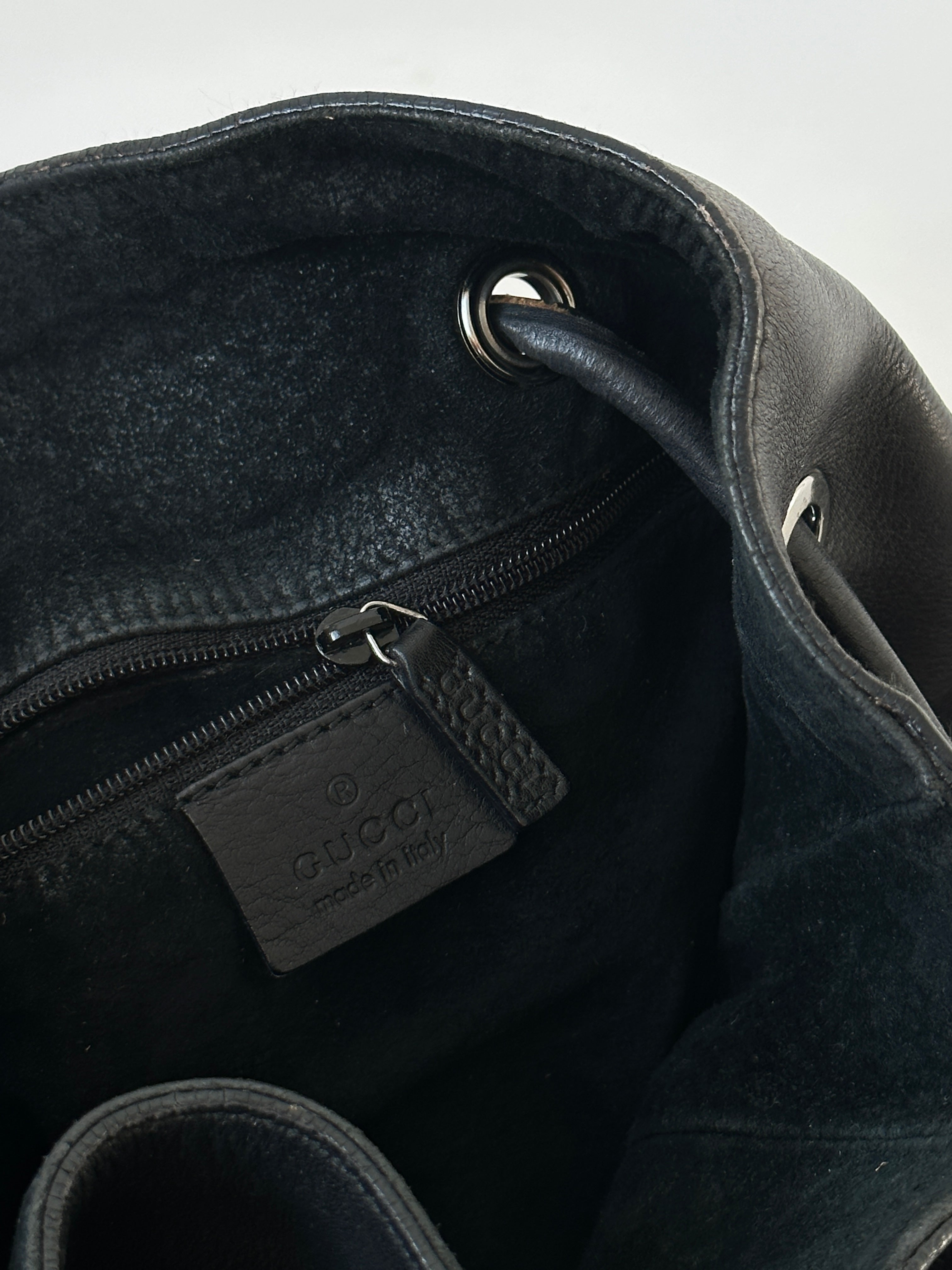 Gucci leather bucket bag with adjustable strap, featuring a smooth finish and elegant design.