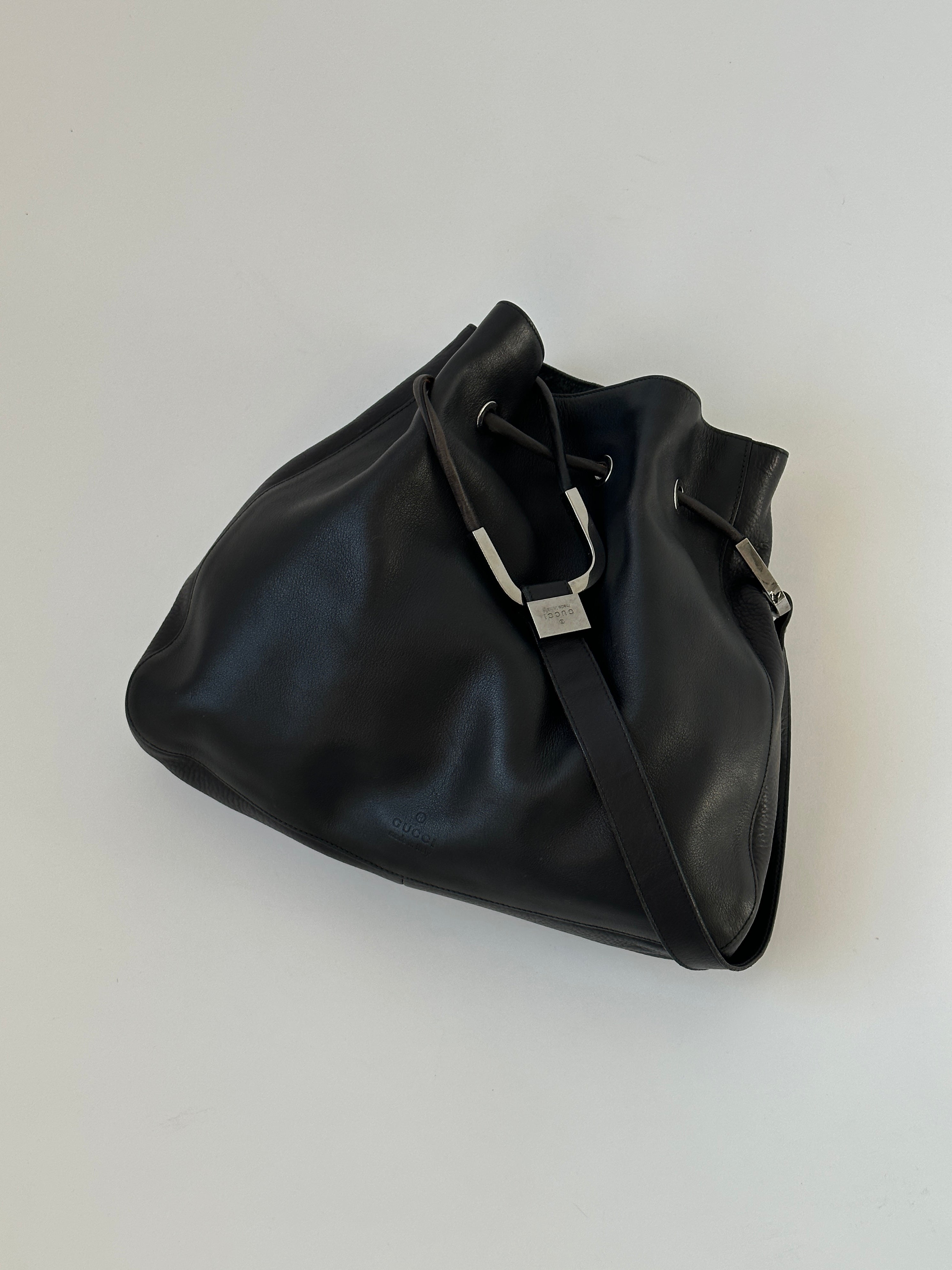 Gucci leather bucket bag with adjustable strap and gold-tone hardware, stylish accessory with designer craftsmanship.