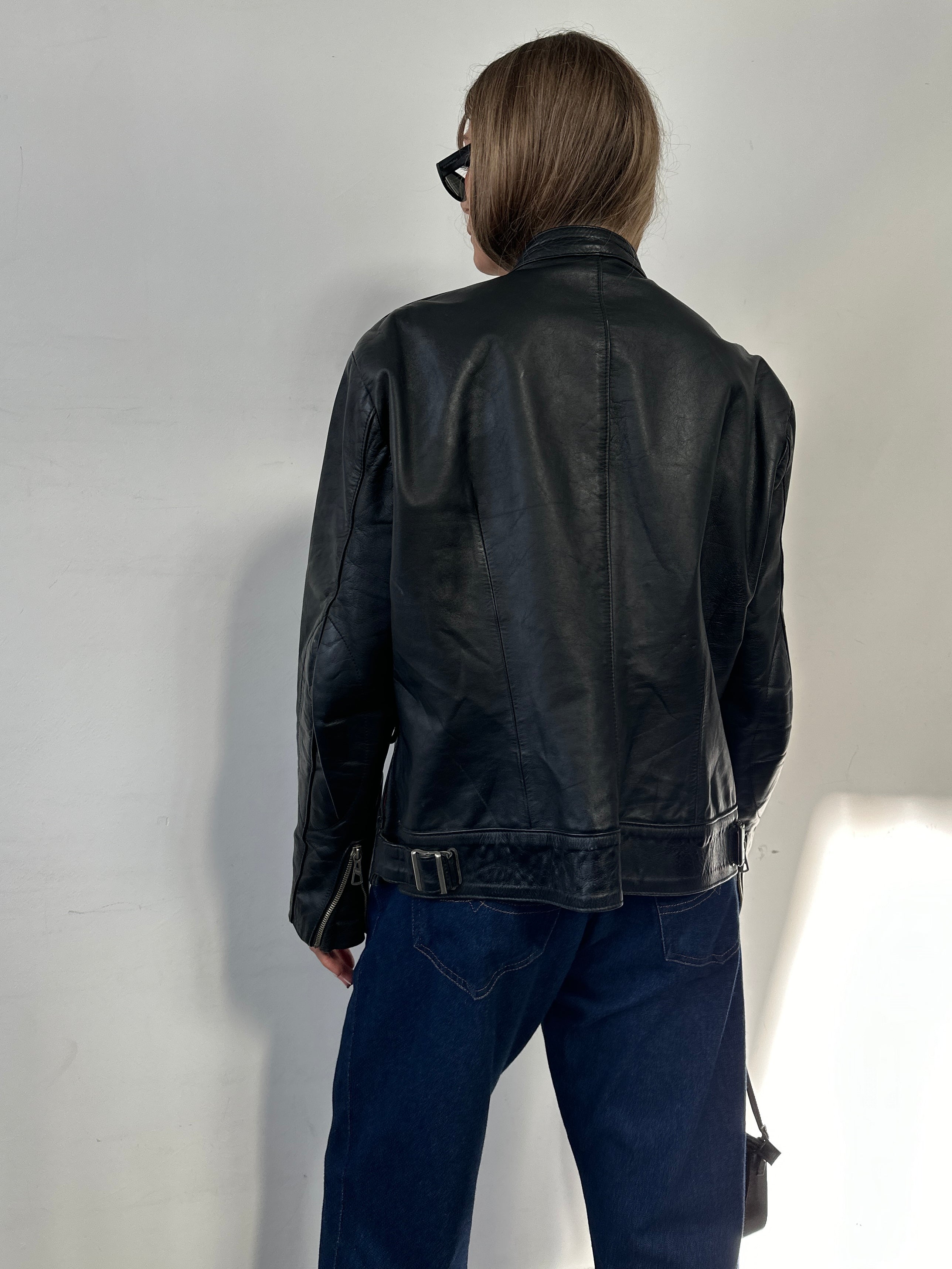 Vintage leather moto jacket in size large, featuring classic design with a rugged, stylish look and detailed stitching.