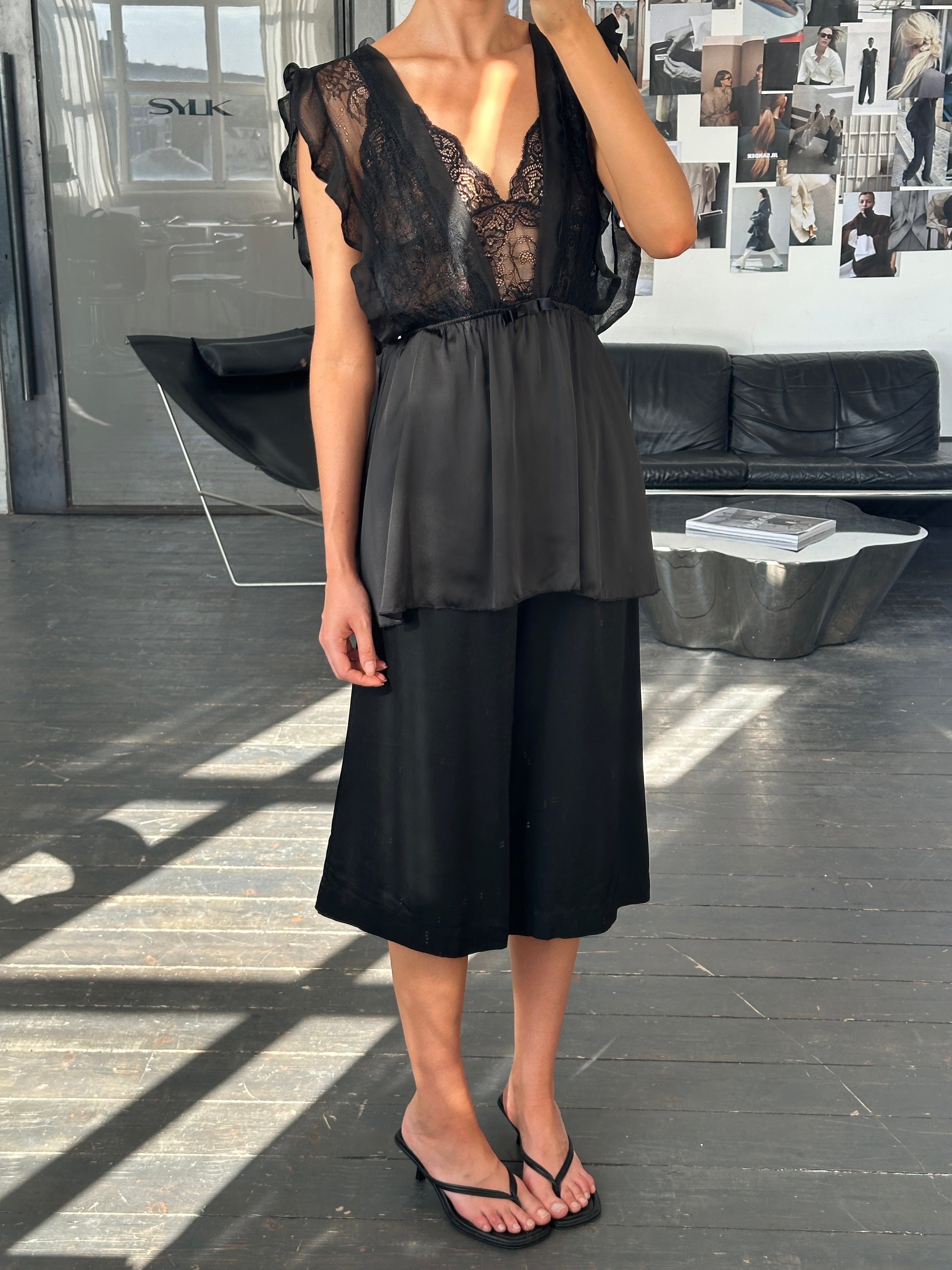 Vintage 1990s wide-leg pleated culottes shorts in W24, featuring high waist and retro style, displayed on a hanger.